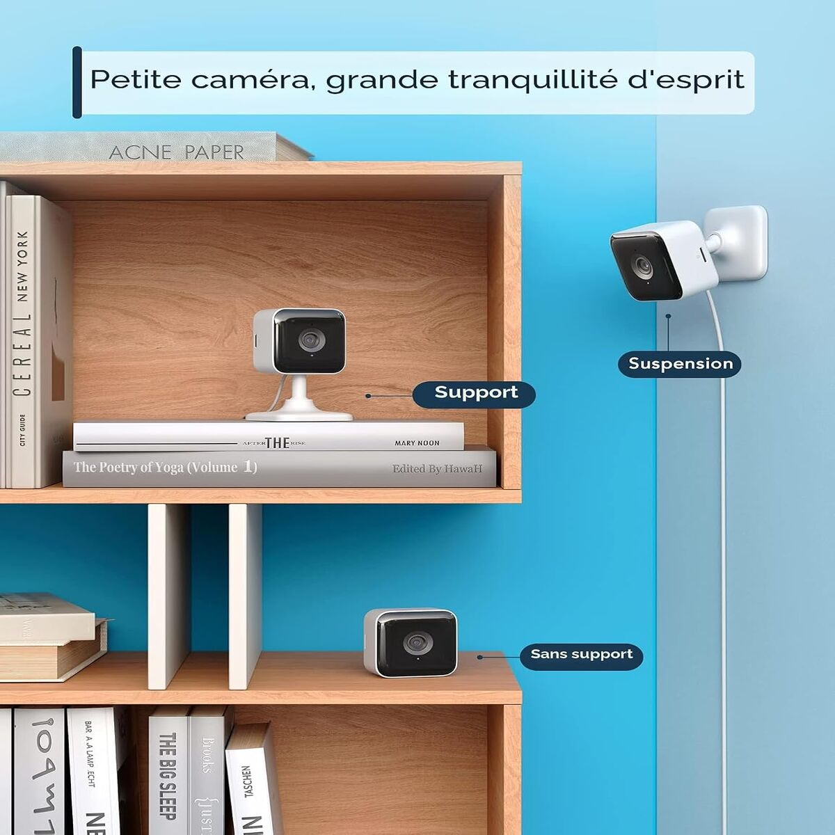 Drei weiße Überwachungskameras in verschiedenen Positionen auf Holzböden neben Büchern und einer blauen Wand.
