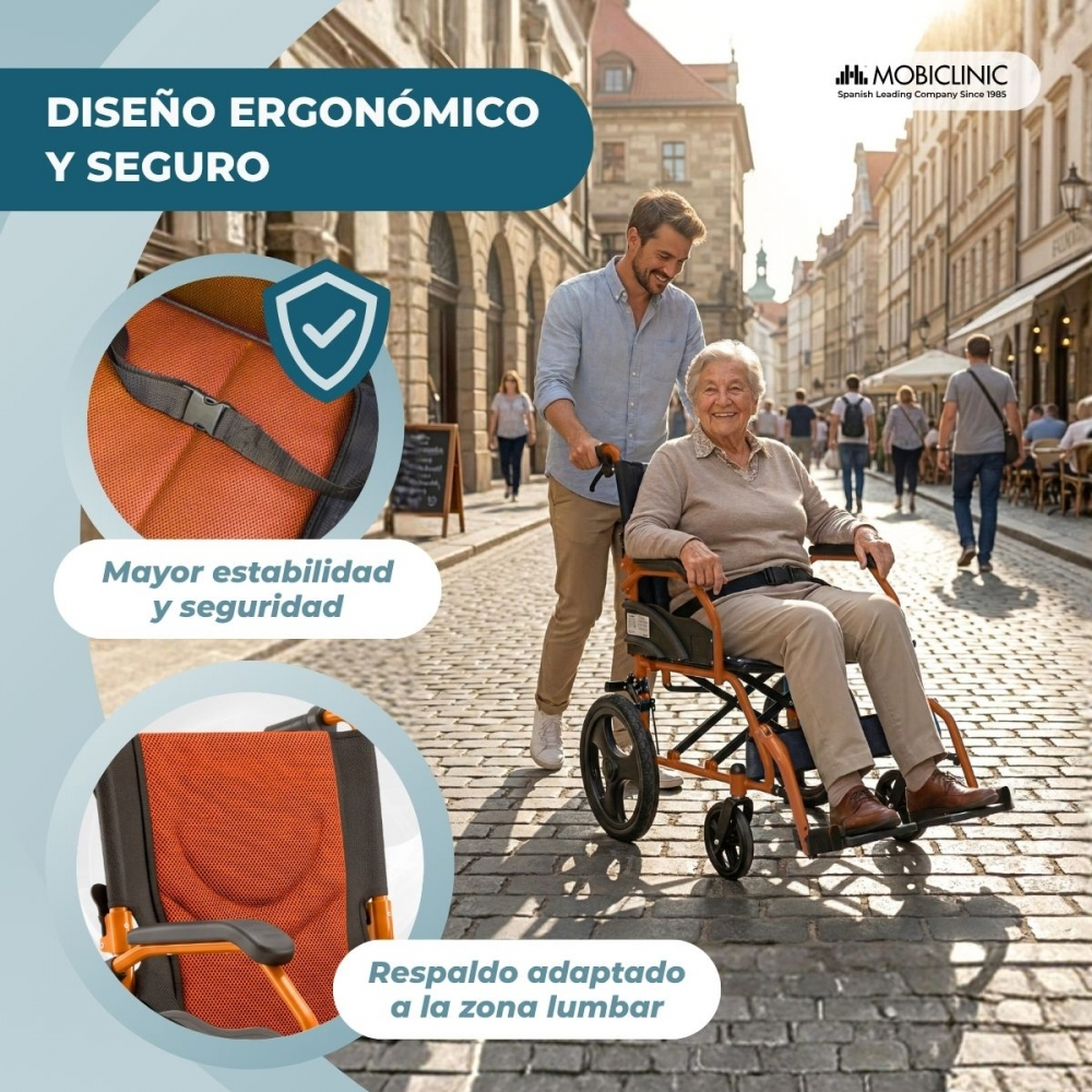 Un hombre empuja a una mujer mayor sonriente en una silla de ruedas naranja por una calle empedrada.