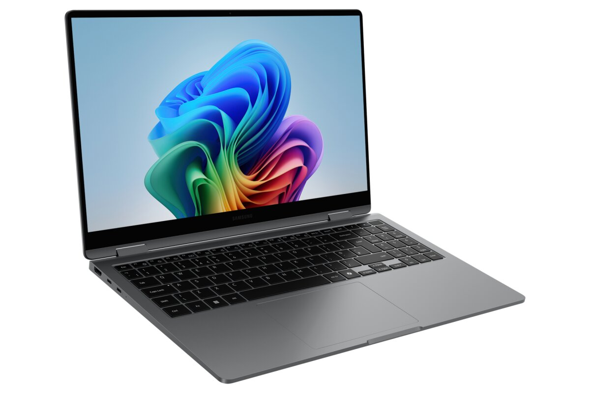 Un computer portatile grigio con tastiera nera e uno sfondo astratto colorato sullo schermo.