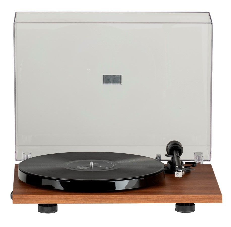 Gramofon w kolorze drewna z czarną płytą winylową i przezroczystą osłoną przeciwpyłową na białym tle.