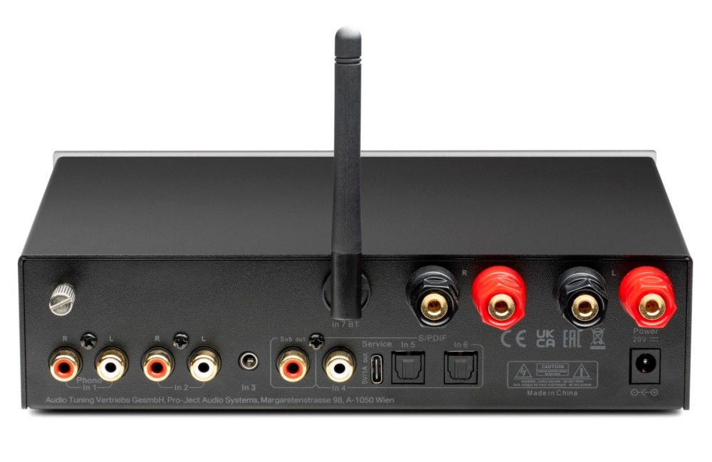 Tylny panel czarnego urządzenia audio z różnymi wejściami, anteną i zaciskami głośnikowymi.