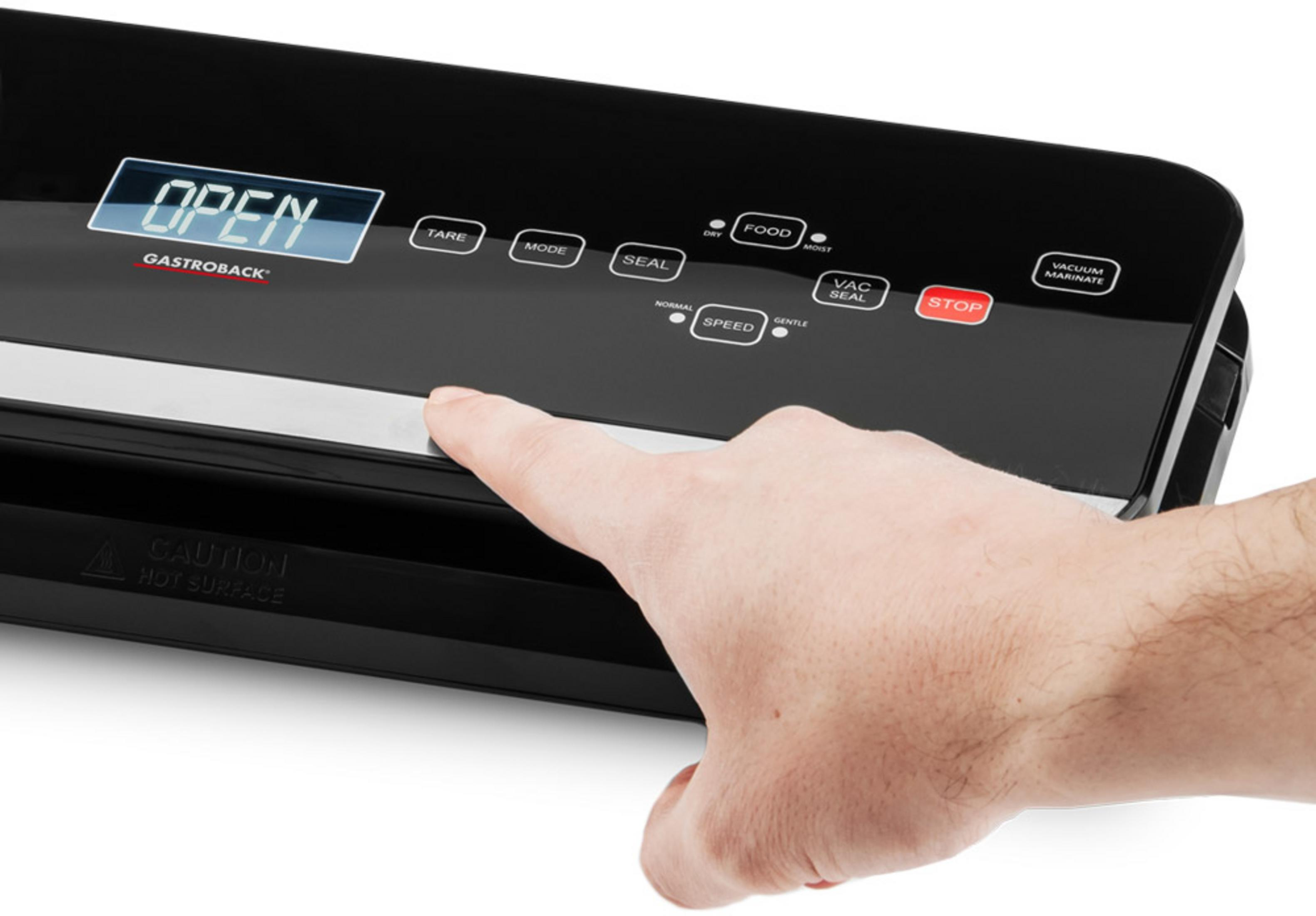 Mano che preme la barra argentata su una macchina sottovuoto nera Gastroback con display.