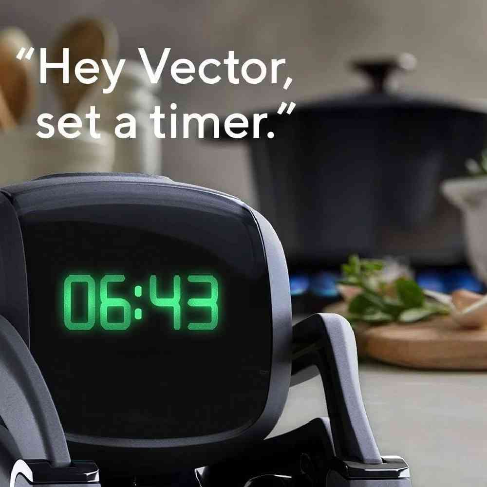 Dijital ekrana sahip küçük bir robot mutfak tezgahında saati gösteriyor. Metin: "Hey Vector, set a timer."