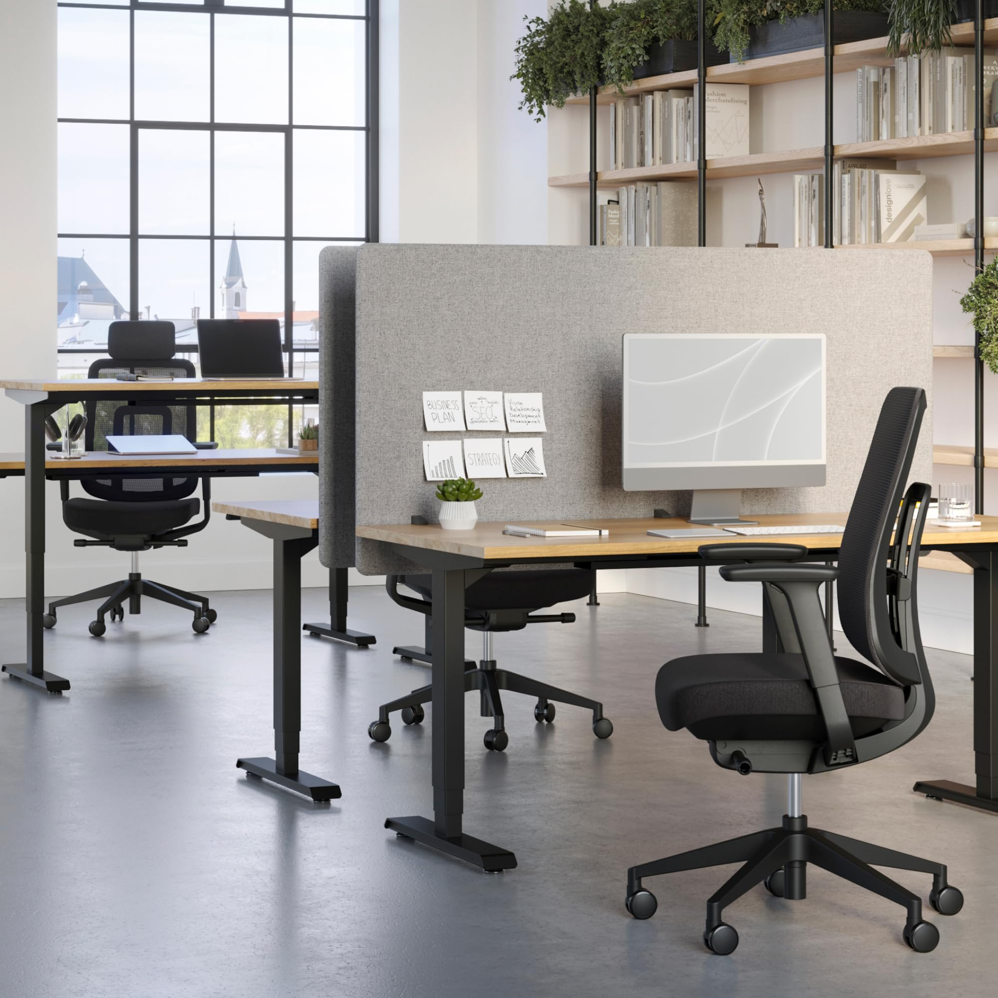 Un bureau moderne avec des bureaux en bois, des chaises noires, un ordinateur et une grande étagère.