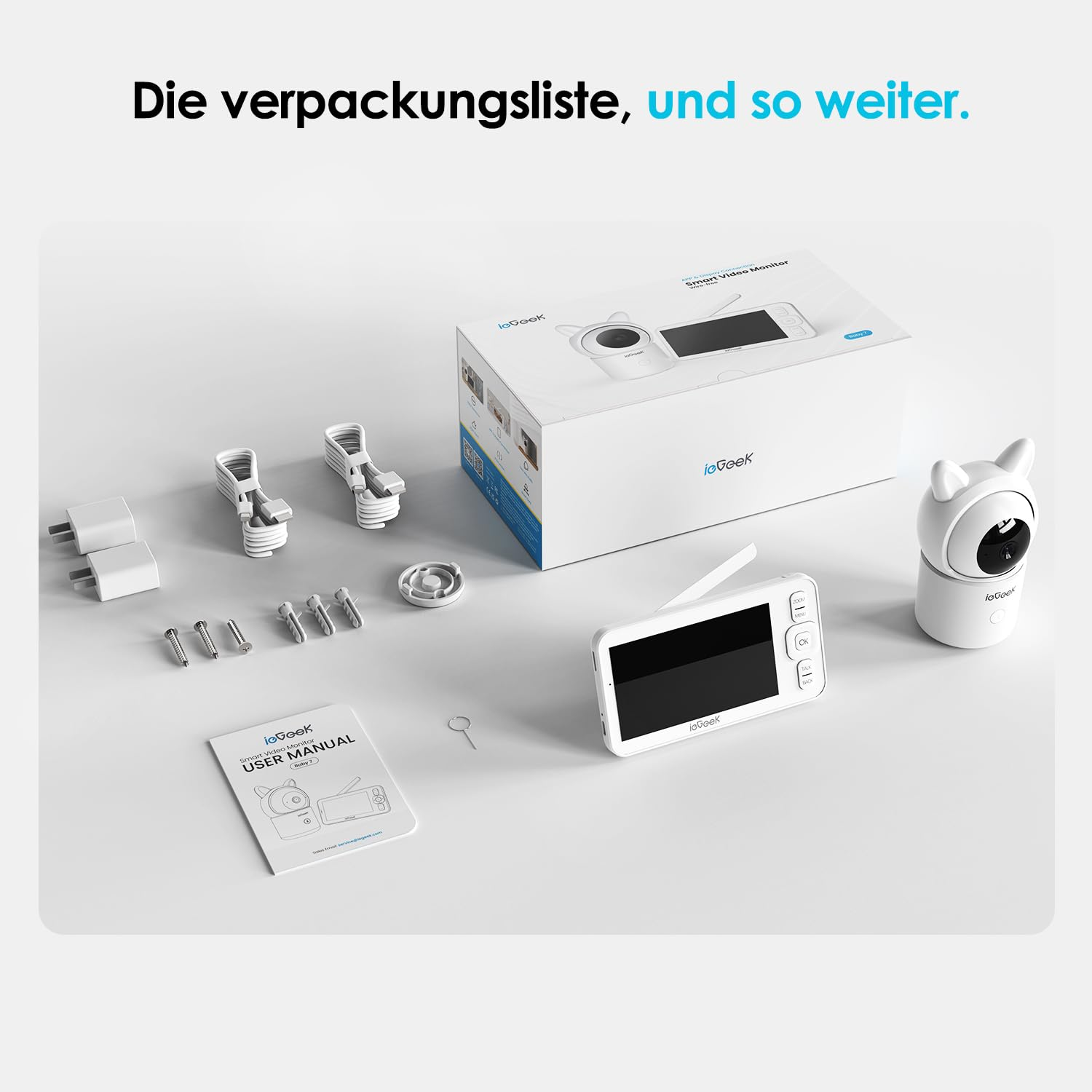 Un kit babyphone avec caméra, écran, câbles, chevilles et manuel disposés proprement sur une surface.