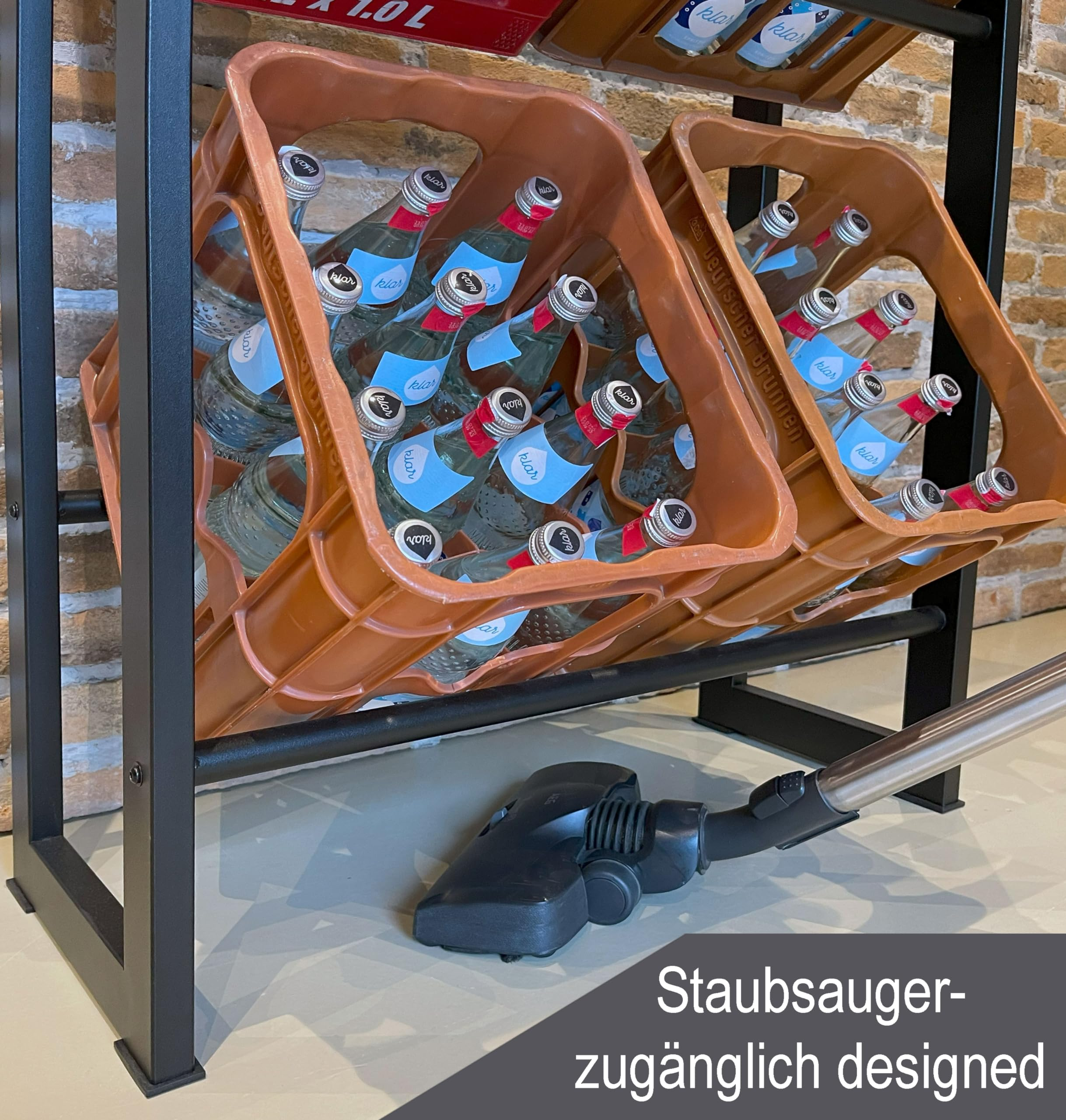 Staubsauber-zugänglich: Ein Staubsauger liegt vor einem Regal mit Glasflaschen in Kisten.