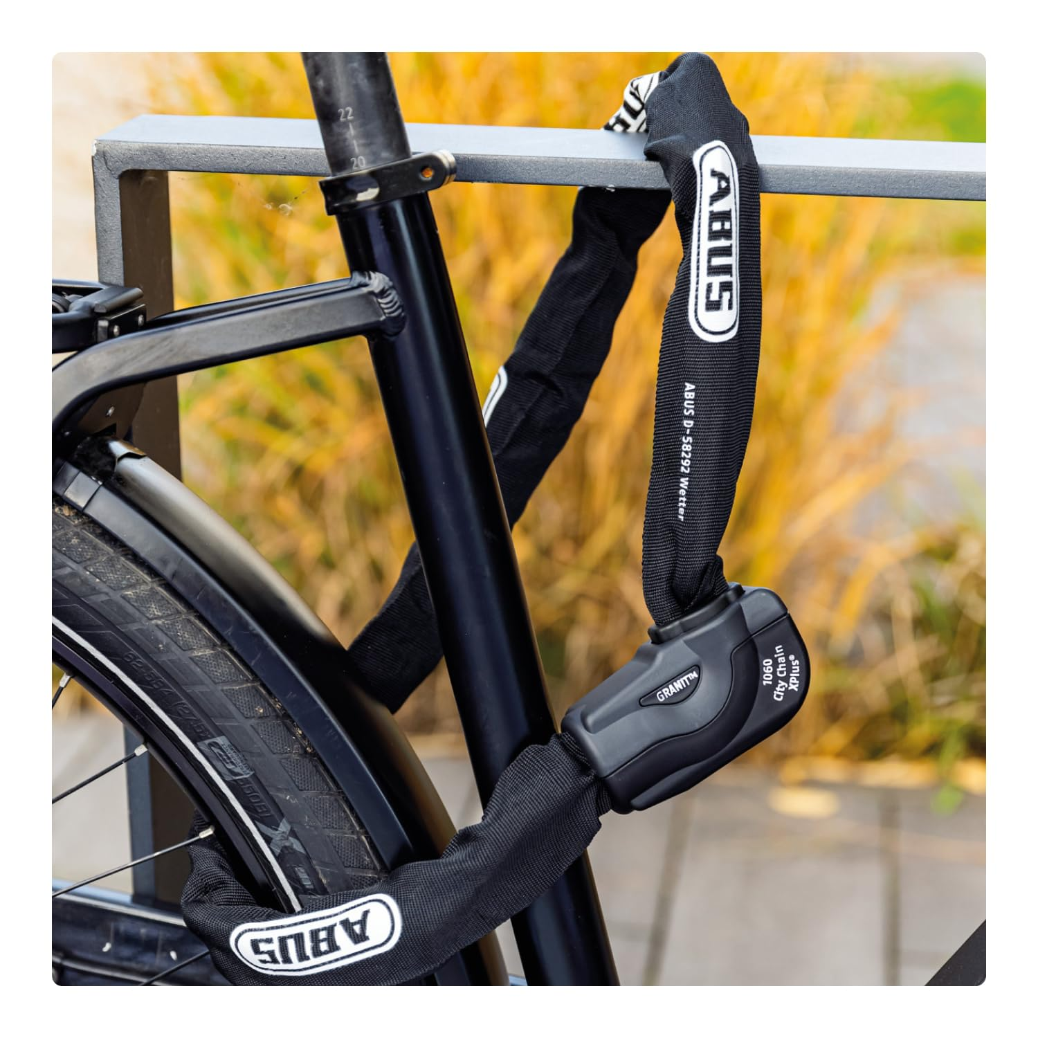 Un antivol de vélo noir Abus sécurise le cadre sur un support métallique.