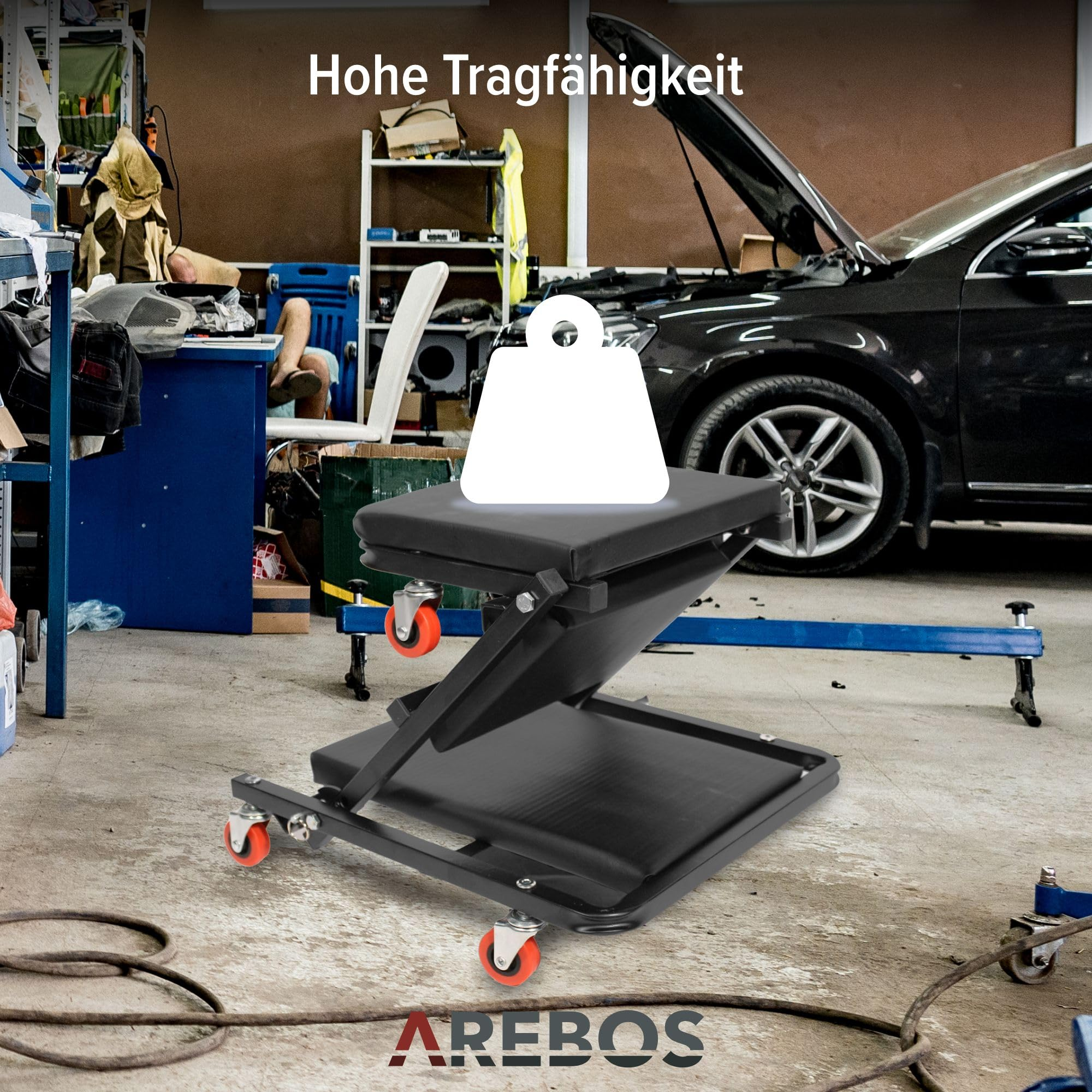 Schwarzer Mechaniker-Rollsitz mit roten Rollen und Ablagefläche in einer Werkstatt mit Auto.