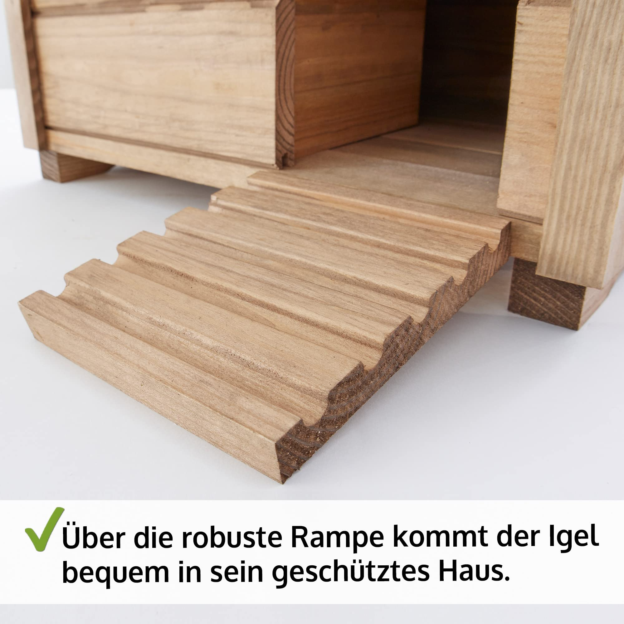 Une maison pour hérisson en bois avec une rampe inclinée menant à l'entrée.