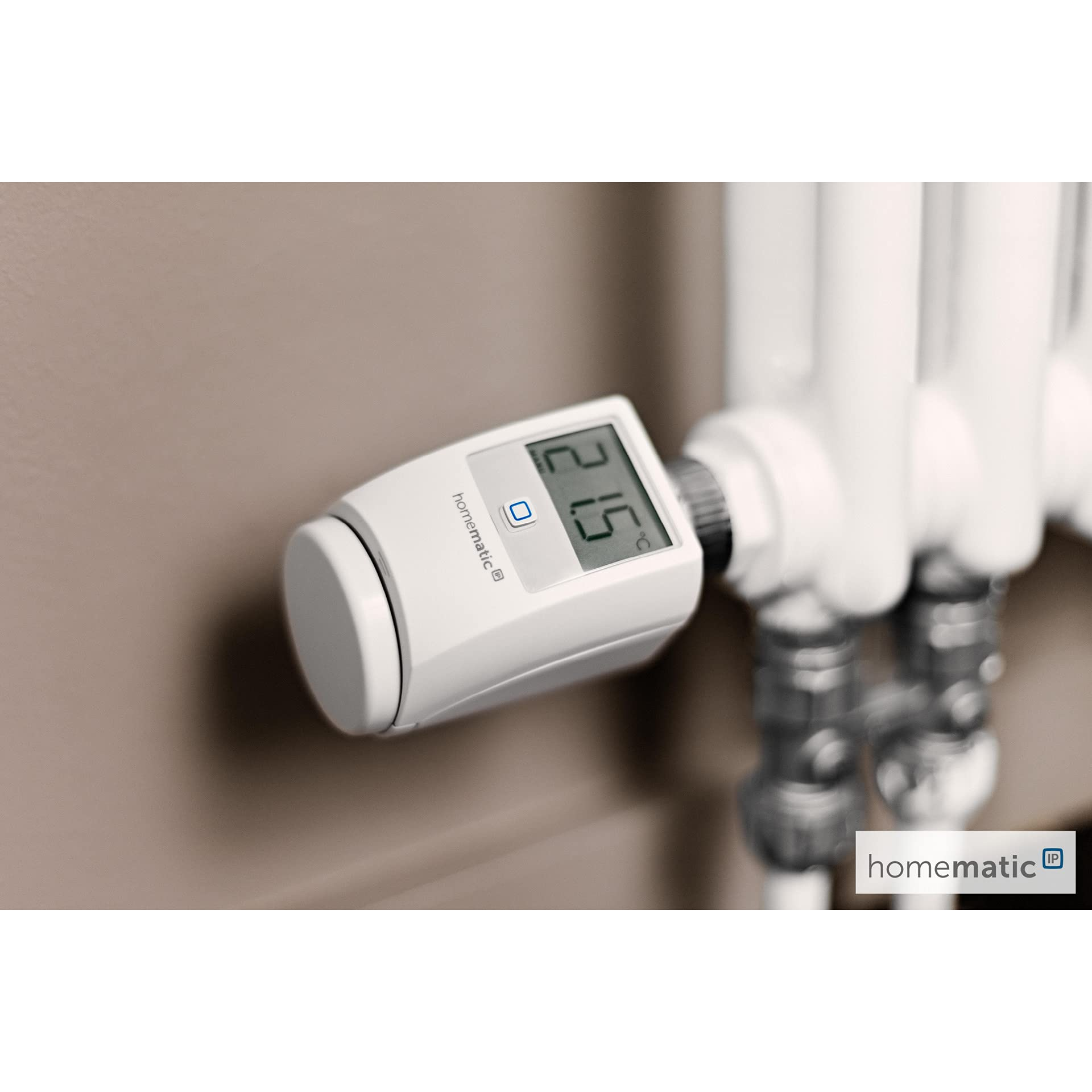 Ein weißes Homematic IP Thermostat an einem weißen Heizkörper vor einer beigen Wand.