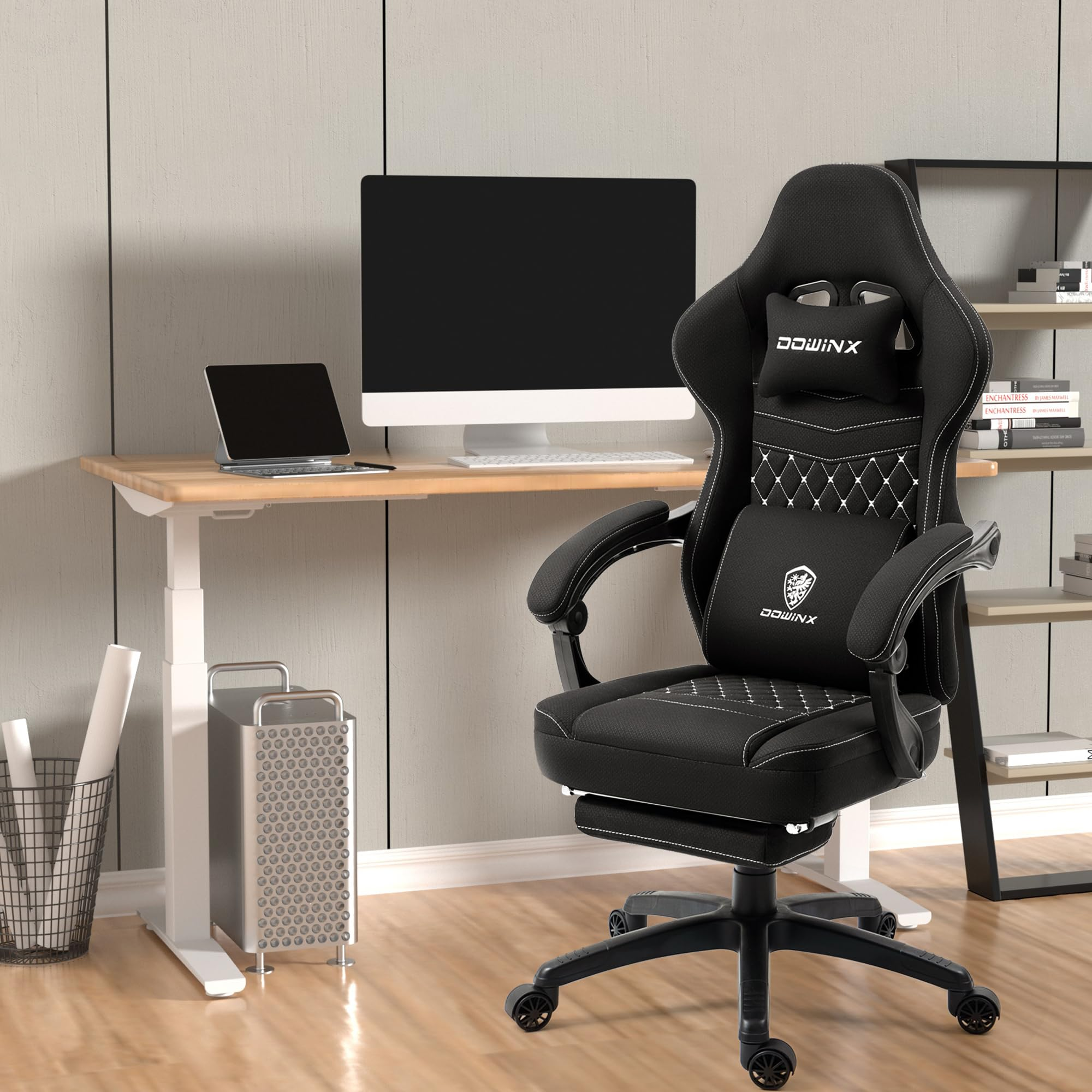 Schwarzer Gaming-Stuhl mit weißem Steppdesign, Kissen und Schreibtisch mit PC im Hintergrund.