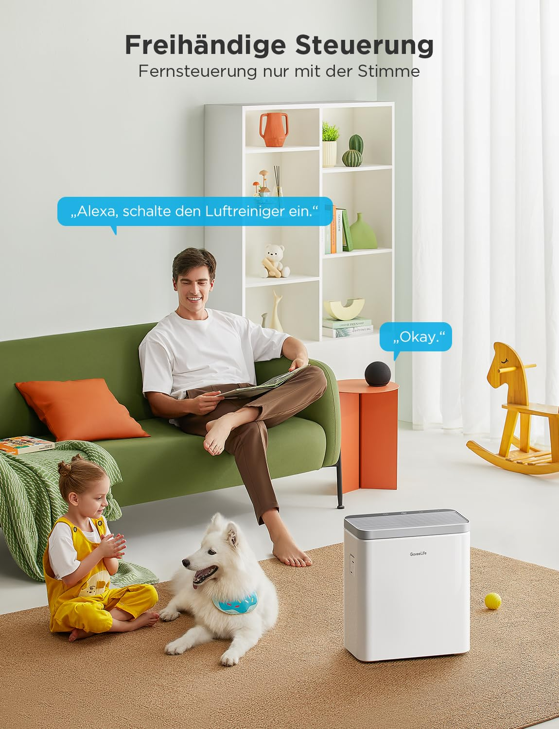 Un uomo su un divano verde parla con uno smart speaker mentre una bambina e un cane giocano.
