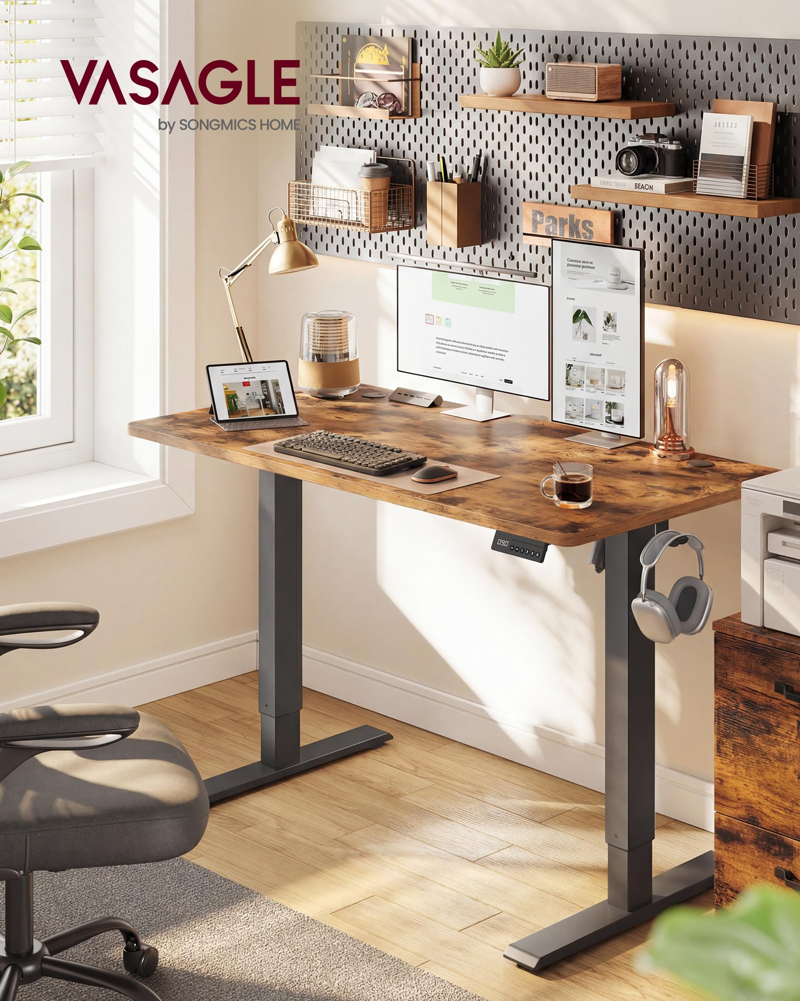 Bureau moderne avec bureau réglable en hauteur, double écran, clavier et accessoires sur un panneau perforé.