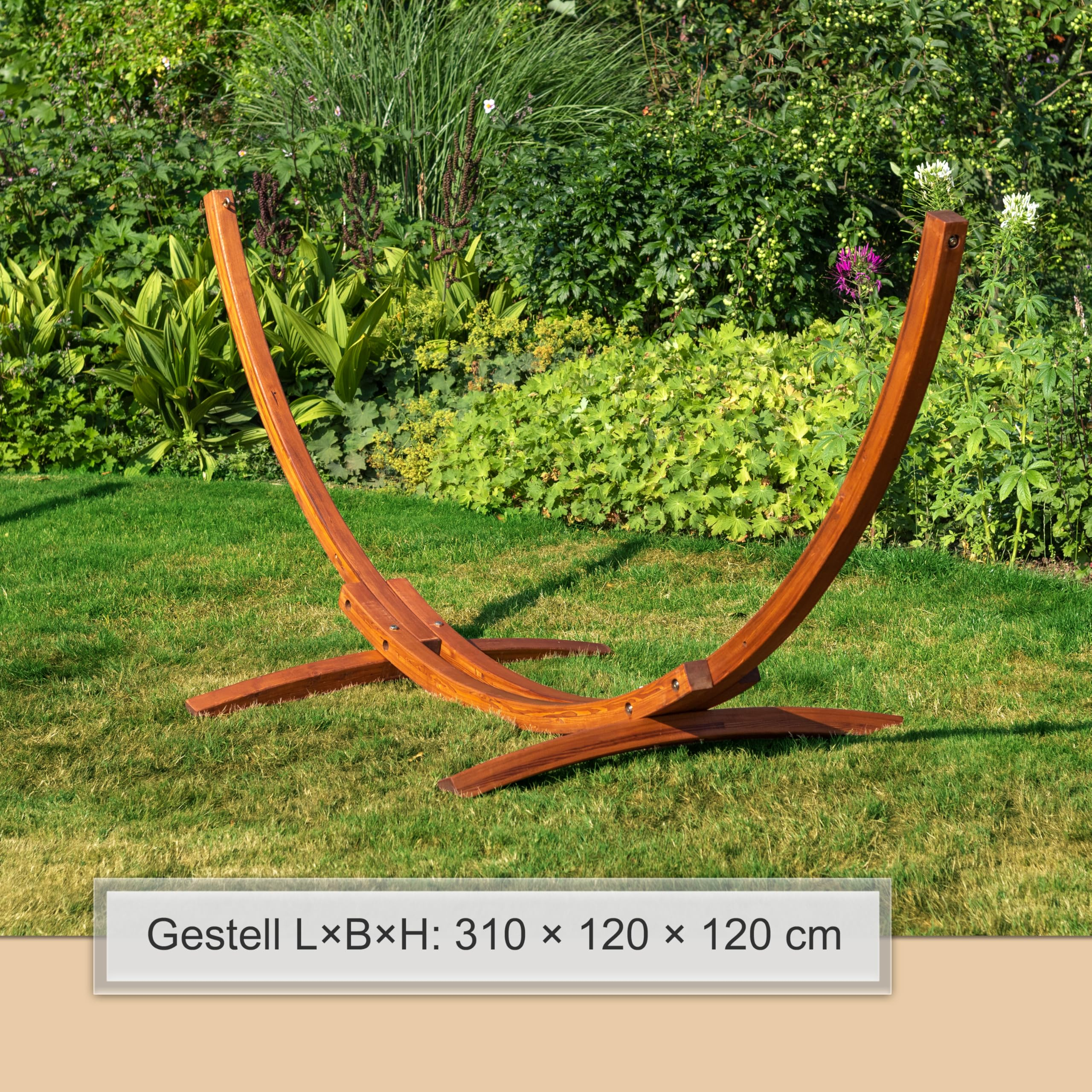 Ein hölzernes Hängematten-Gestell steht auf einem grünen Rasen vor Gartenpflanzen.