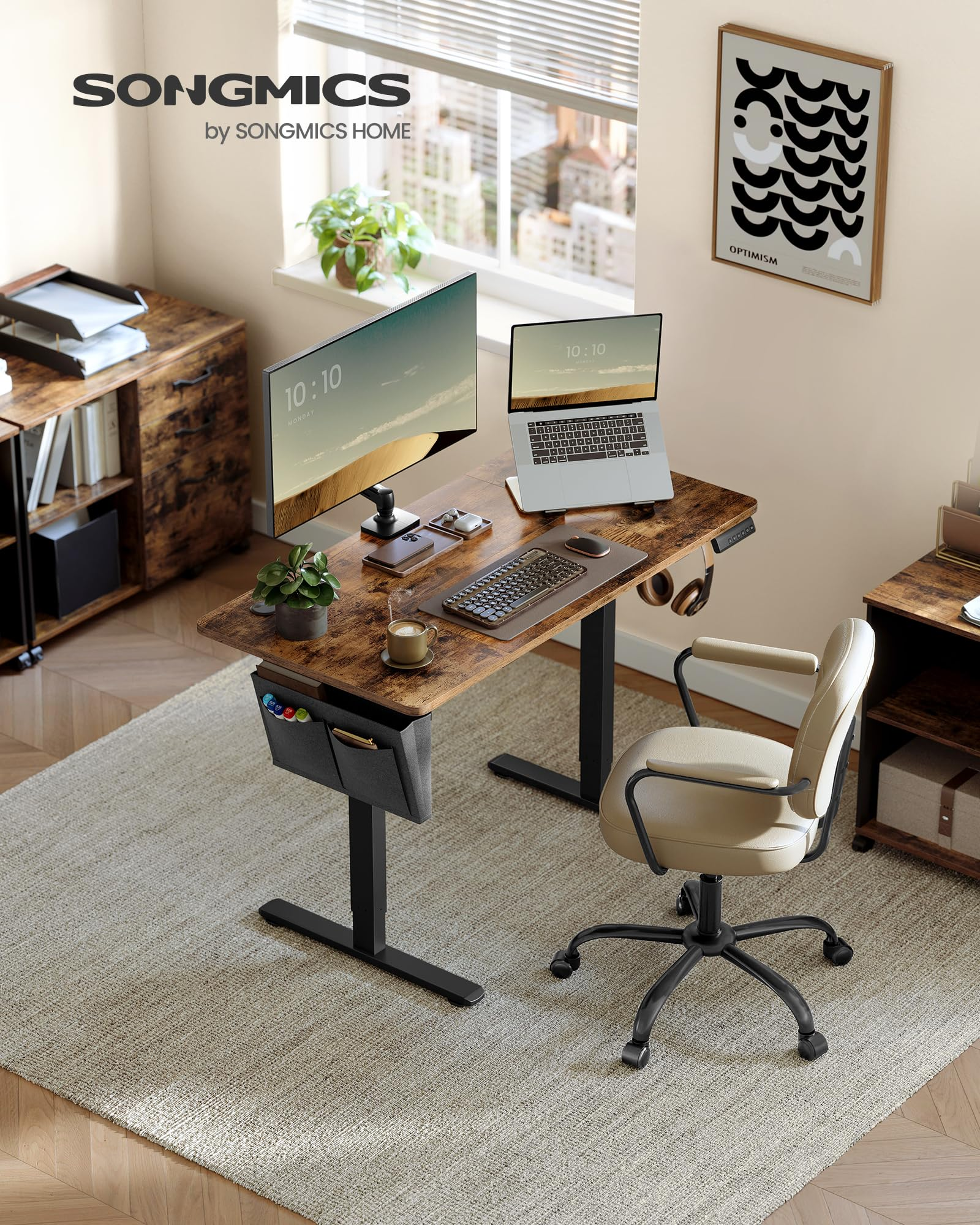 Un bureau debout en bois avec moniteur, ordinateur portable et clavier, et une chaise de bureau beige sur un tapis.