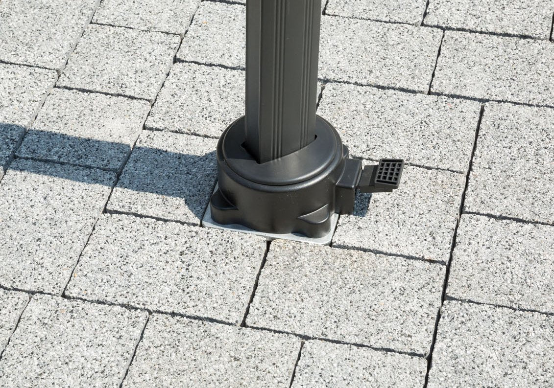 Ein grauer Pavillonpfosten steht stabil auf einem grauen Pflastersteinboden.