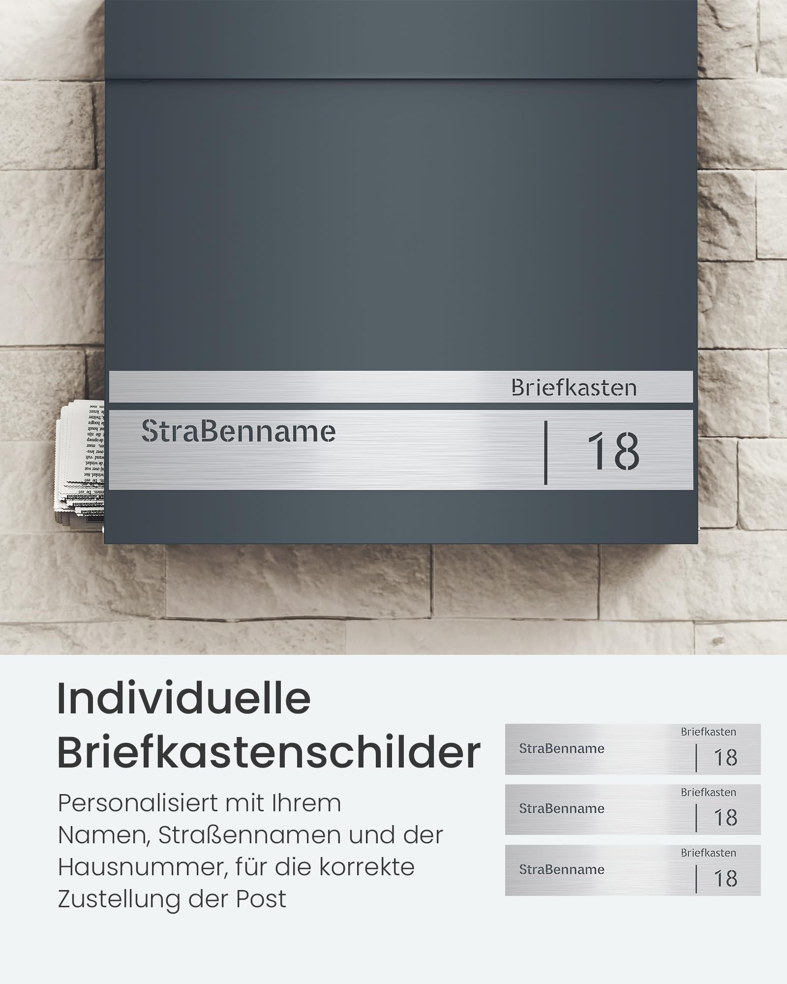 Boîte aux lettres gris foncé avec plaque en acier inoxydable personnalisée sur un mur en pierre.