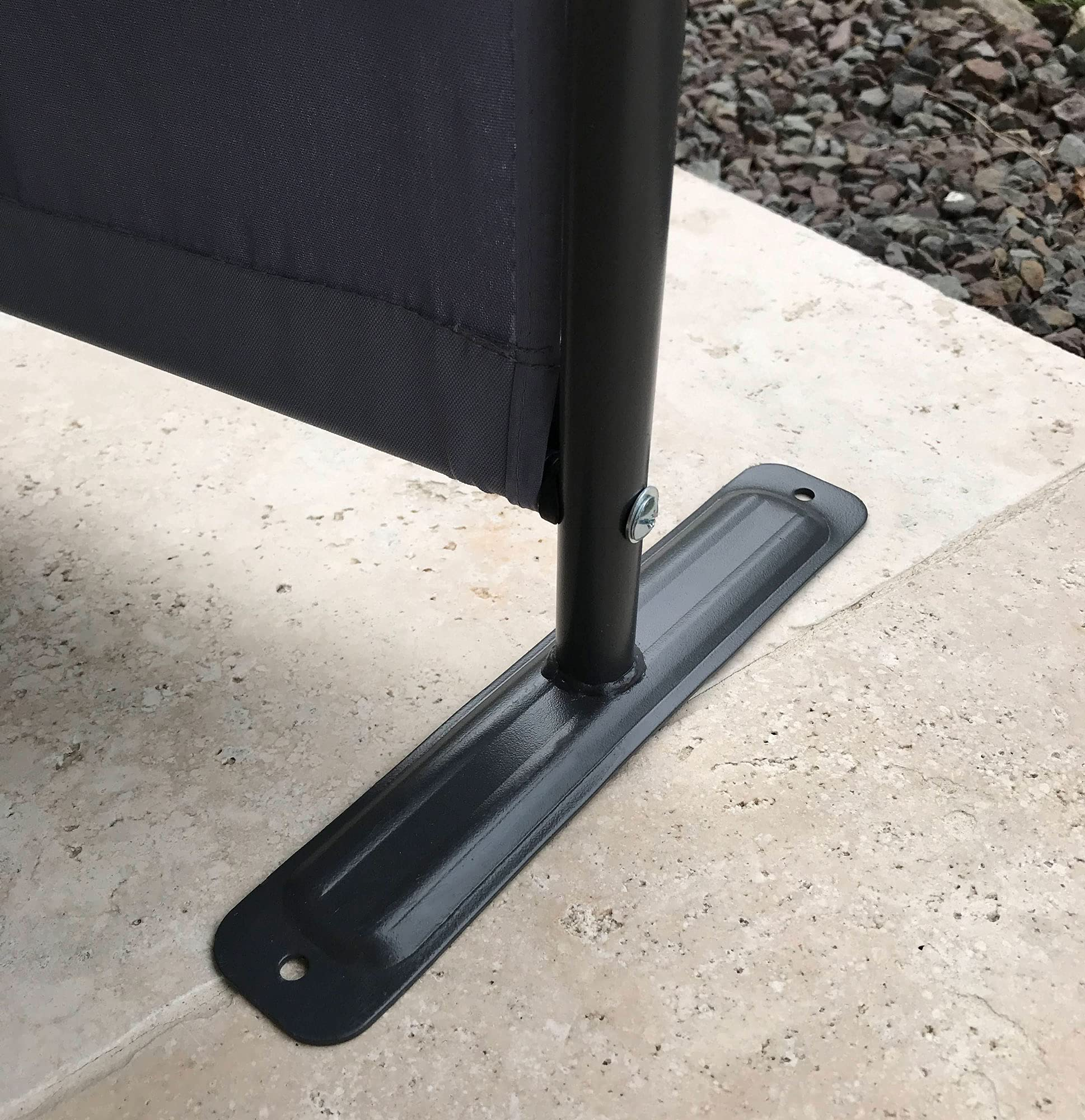 Ein schwarzer Metallpfosten mit Stoffbespannung steht auf einer rechteckigen Metallplatte auf hellem Steinboden.