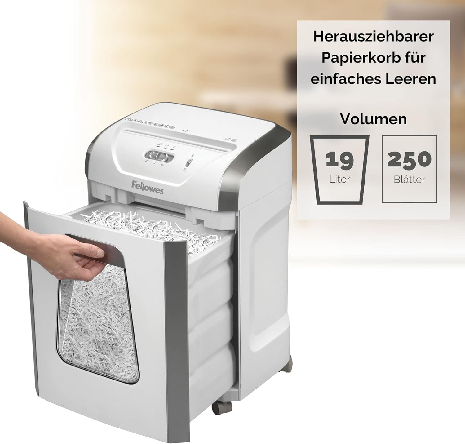 Eine Hand zieht den Papierkorb eines Fellowes Aktenvernichters heraus, gefüllt mit geschreddertem Papier.