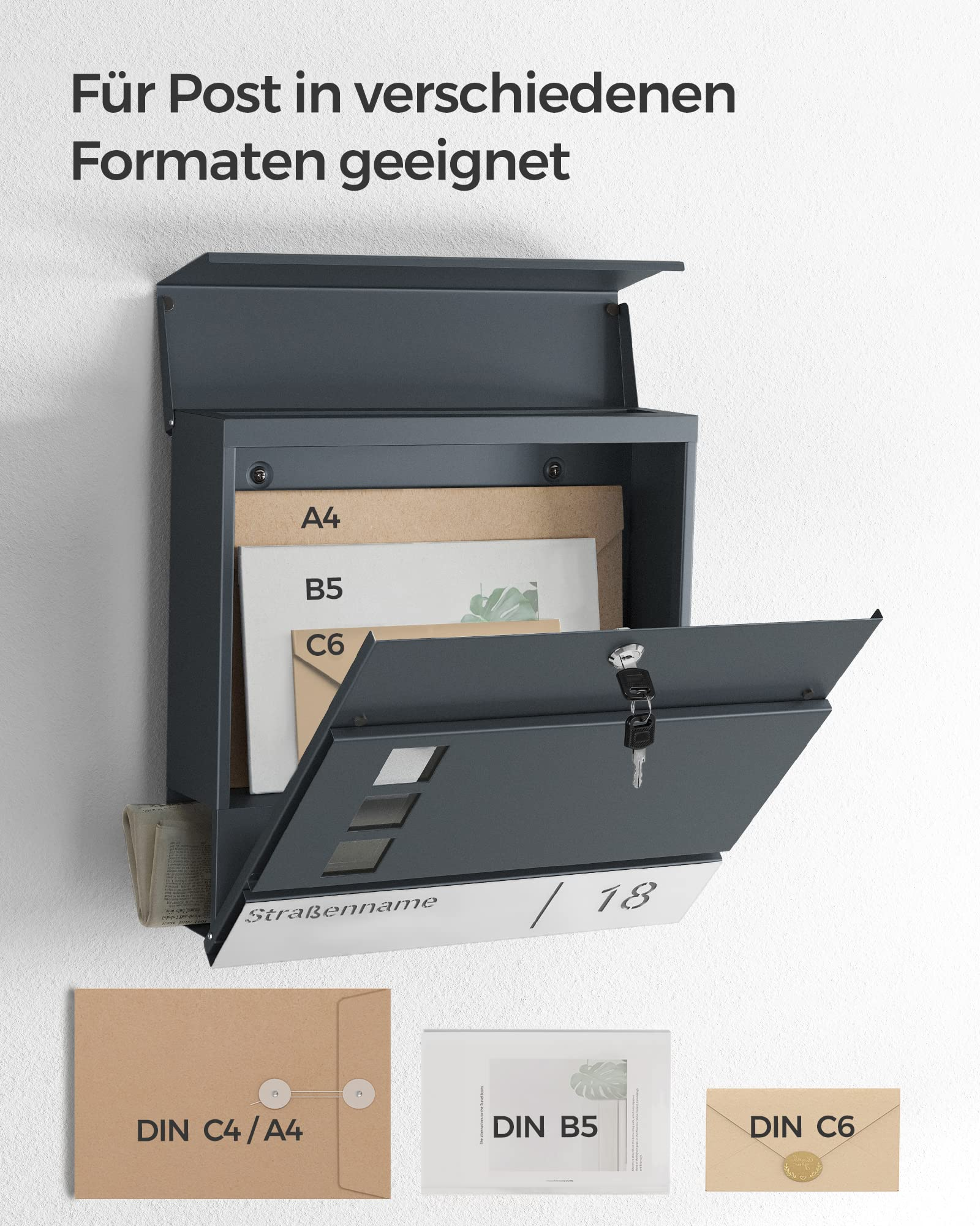 Boîte aux lettres murale gris foncé avec clapet ouvert, remplie d'enveloppes et de magazines A4, B5 et C6.