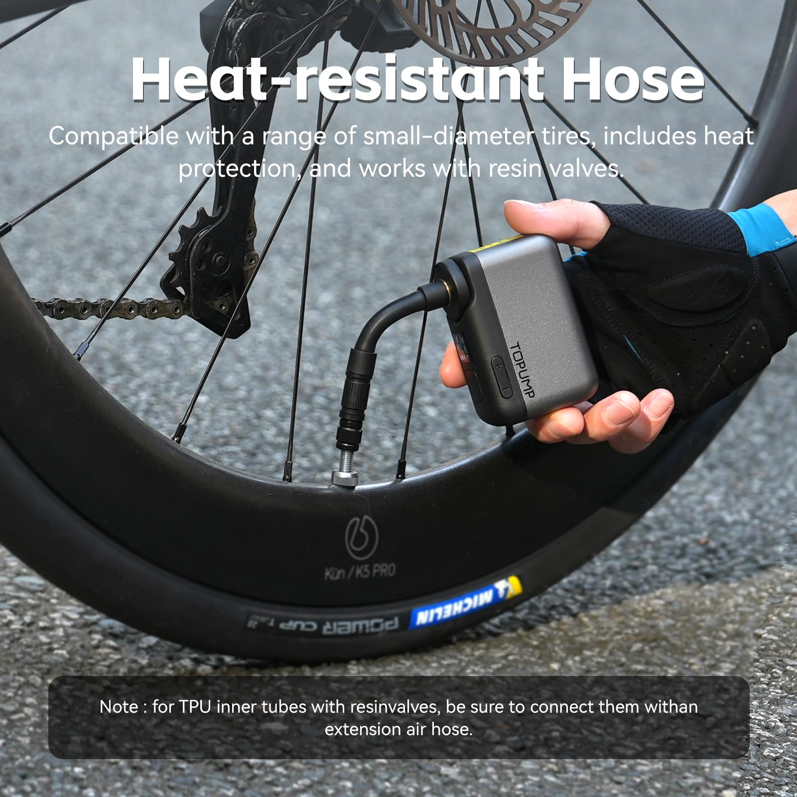 Hand hält kompakte elektrische Fahrradpumpe beim Aufpumpen eines Reifens.