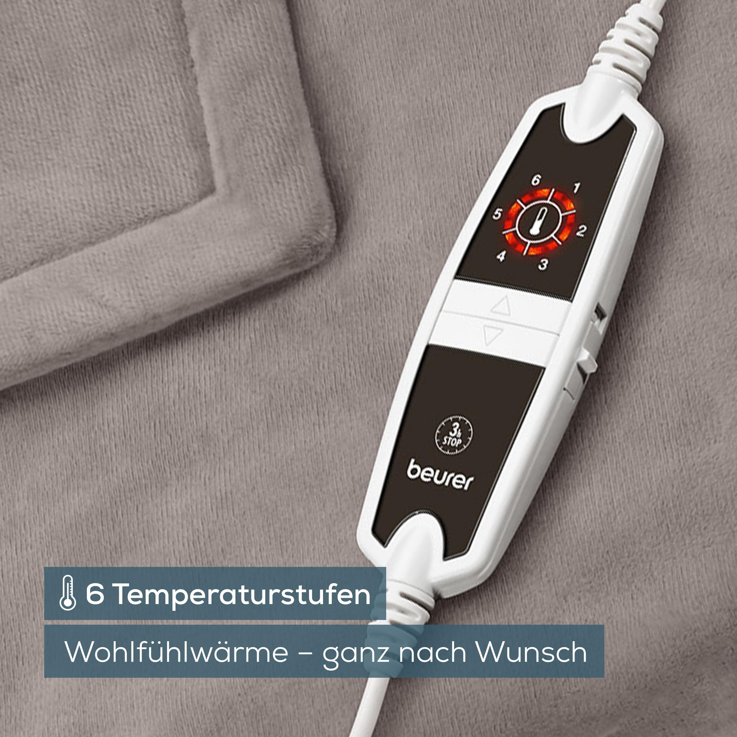 Telecomando per coperta riscaldante Beurer bianco con display illuminato su tessuto grigio.