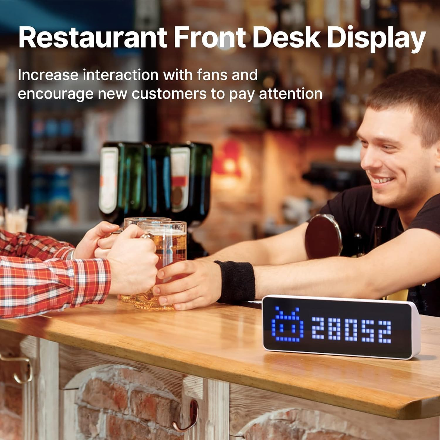 Barista e cliente brindano con boccali di birra al banco, accanto a un display digitale.