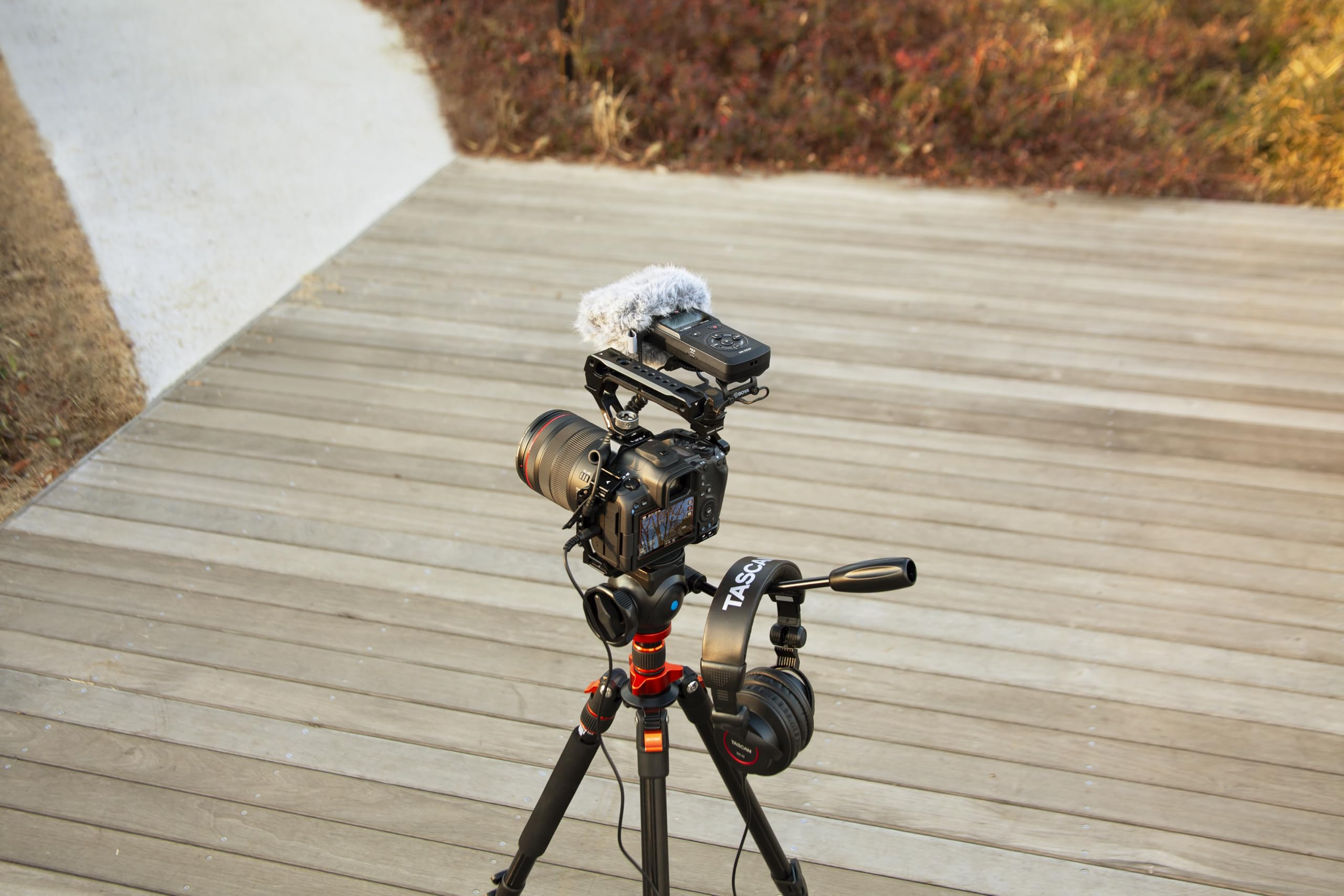 Appareil photo reflex avec micro sur trépied en terrasse bois.