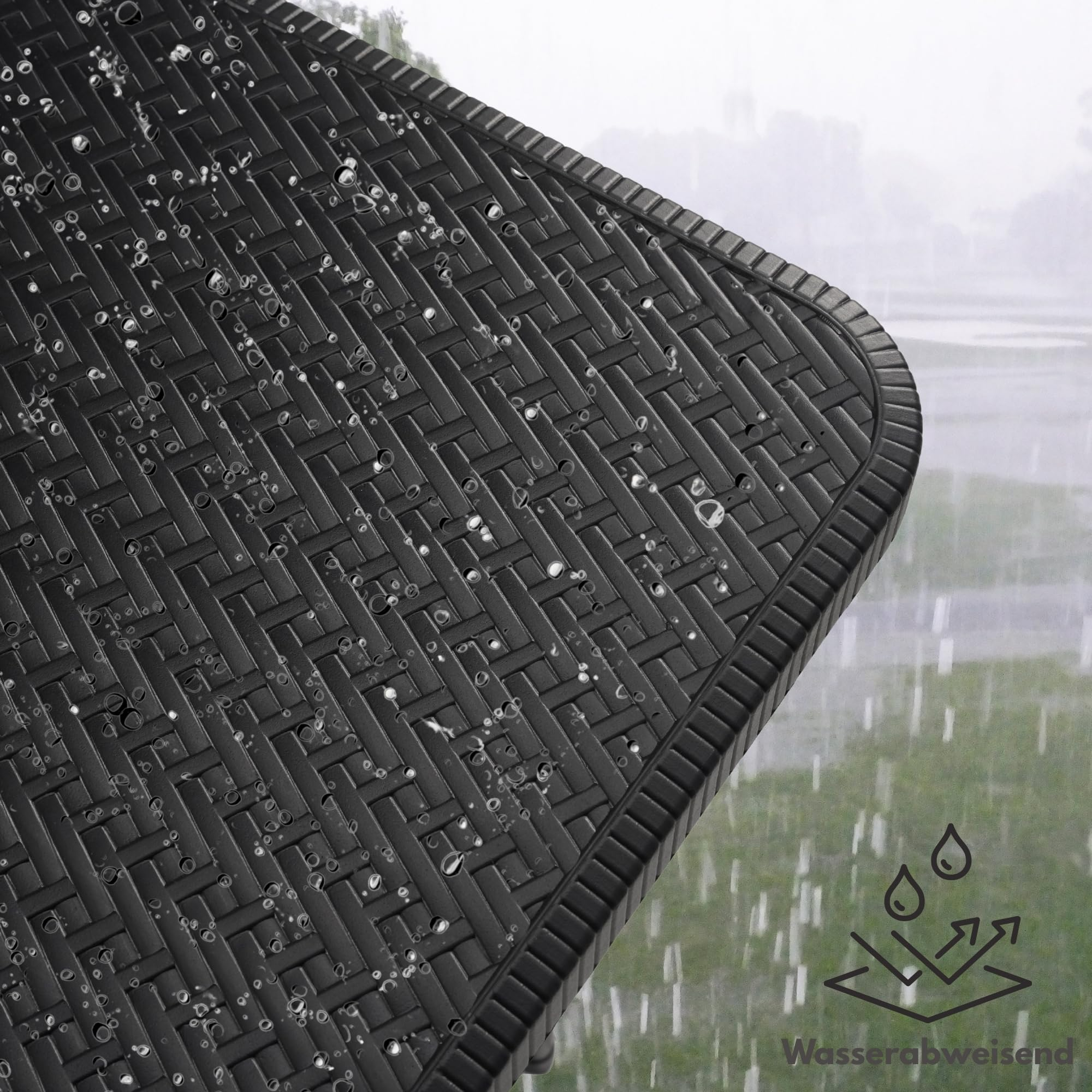 Wassertropfen perlen von einer schwarzen Rattan-Möbeloberfläche ab, während es draußen regnet.