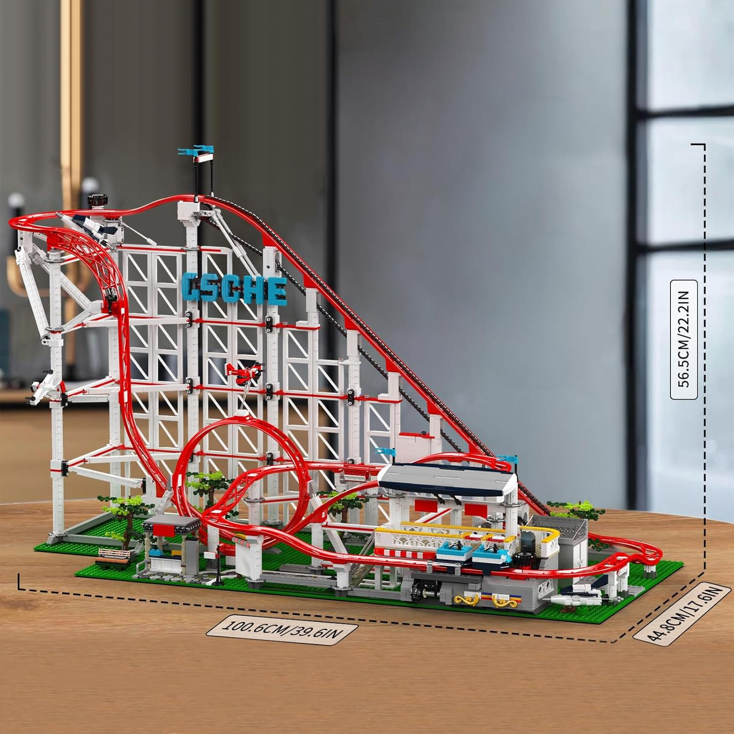 Ein großes, detailliertes Lego-Achterbahnmodell auf einem Holztisch mit Maßangaben.