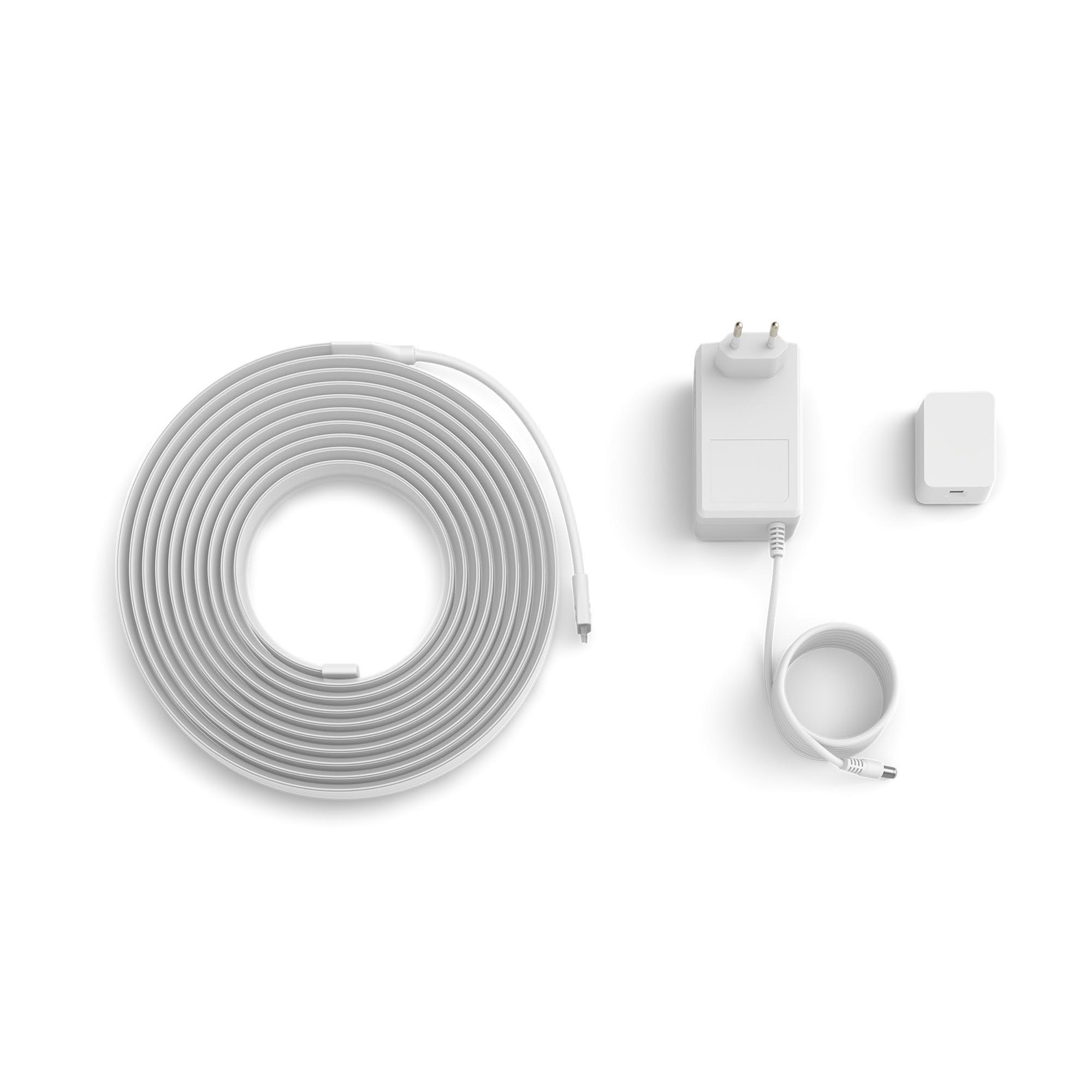 Ein weißes langes Kabel aufgerollt, ein Netzteil mit Kabel und ein kleiner weißer Stecker auf weißem Hintergrund.