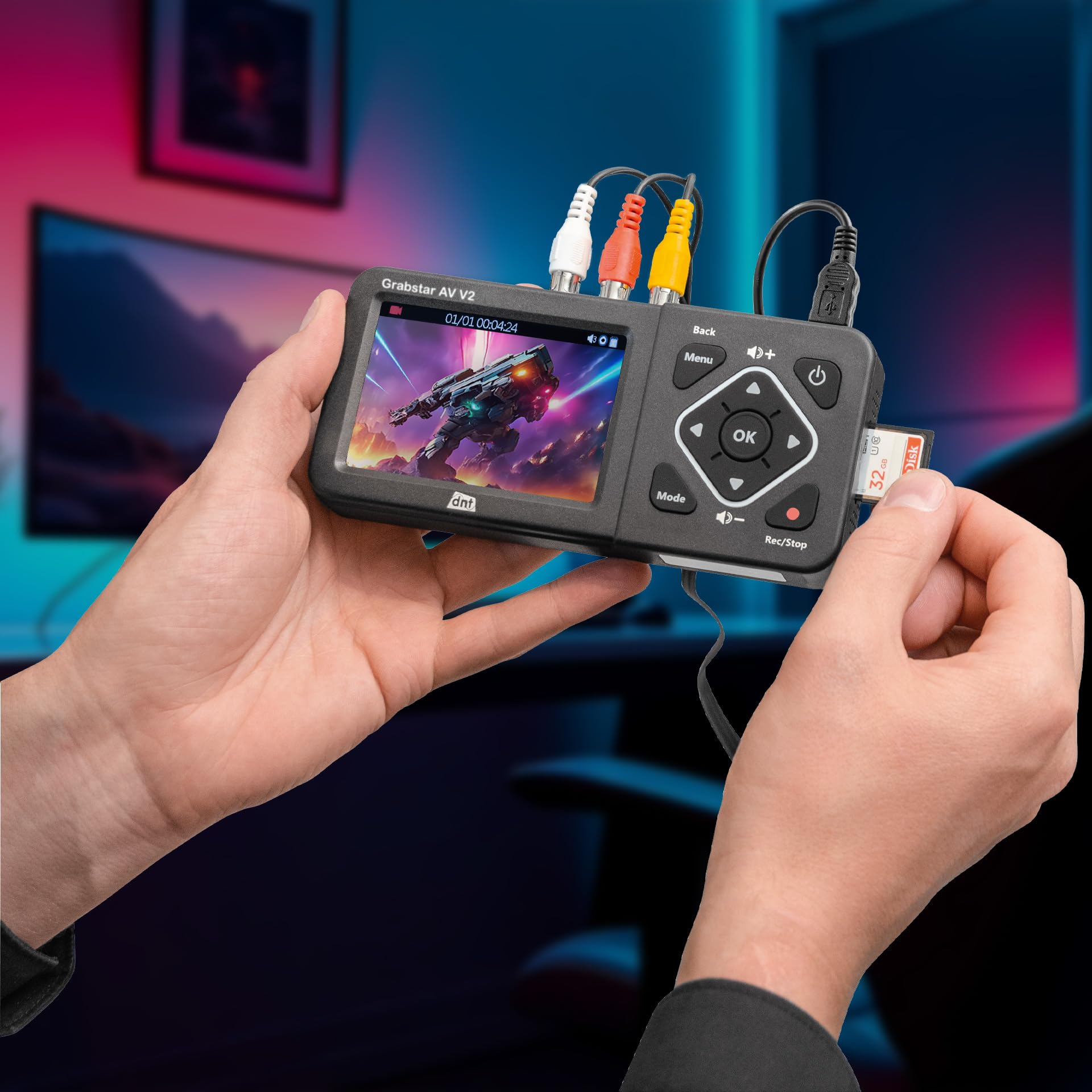 Une personne tient un enregistreur vidéo Grabstar AV V2 avec des câbles connectés et insère une carte SD.
