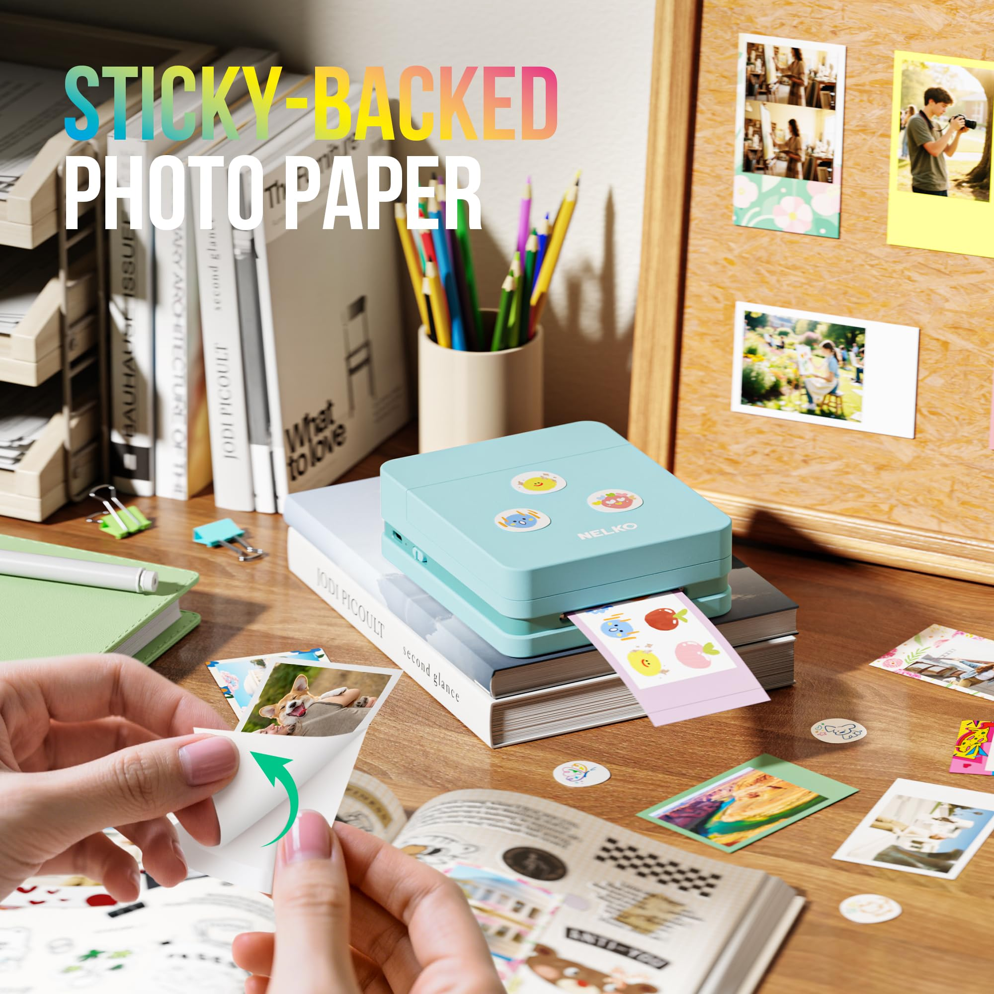 Mini stampante fotografica blu su libri che stampa adesivi su scrivania.