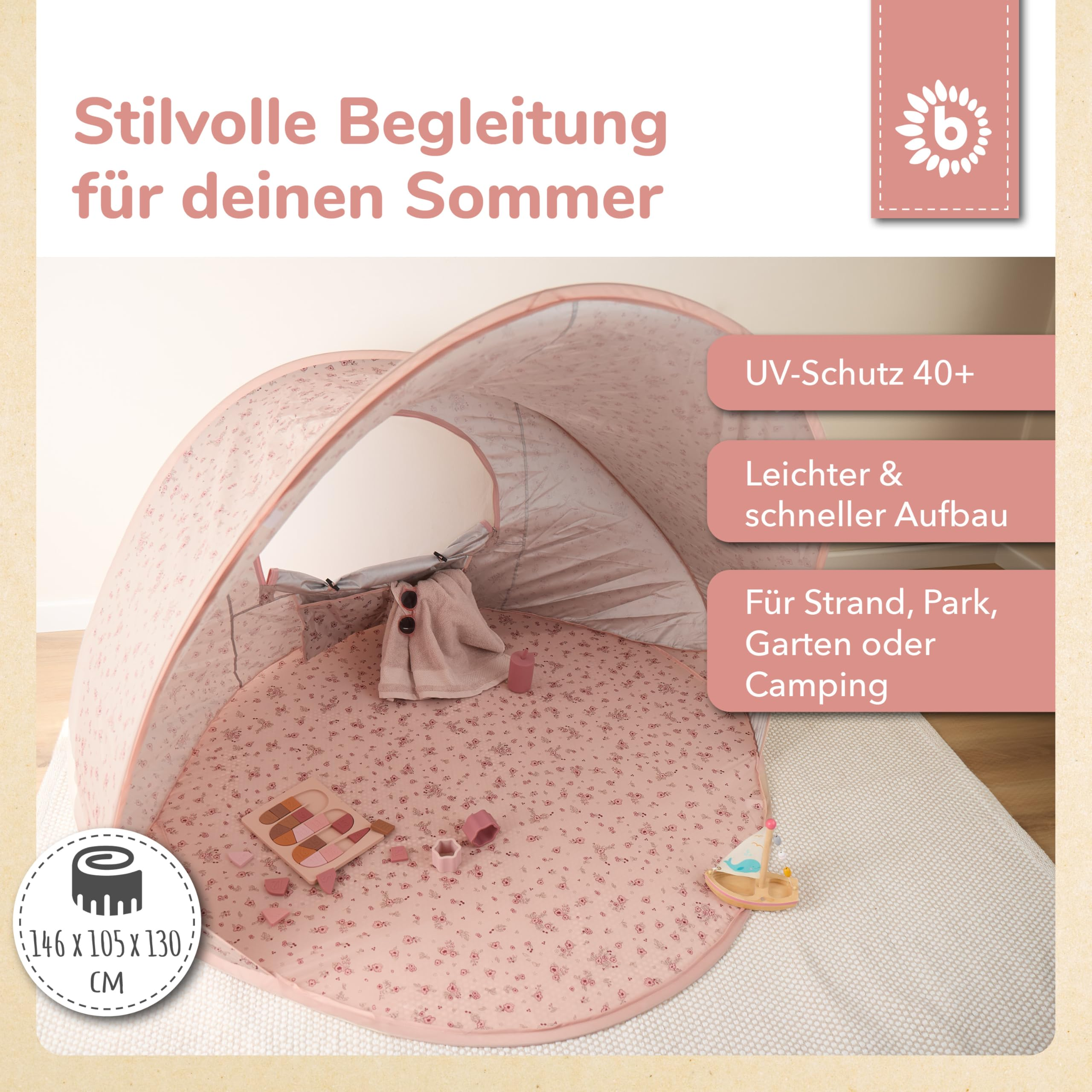 Une tente de plage rose à fleurs pour bébé avec jouets, serviette et texte.