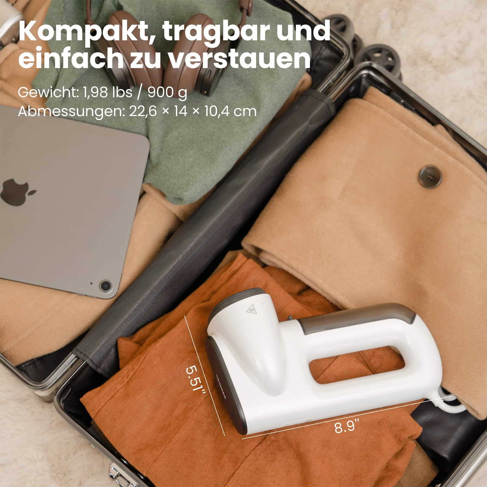 Valise ouverte contenant un défroisseur vapeur, une tablette, un casque et des vêtements.