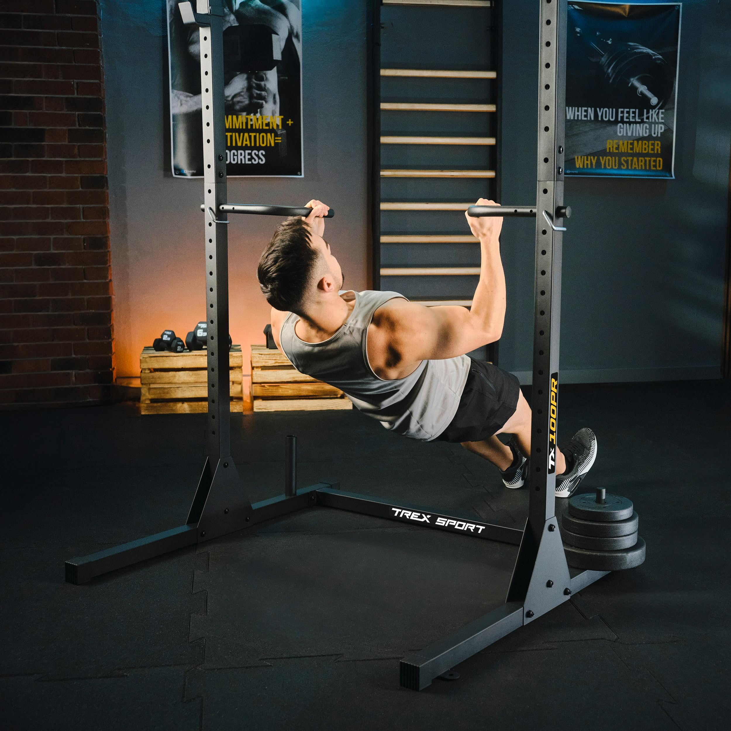 Ein Mann in Sportkleidung macht Klimmzüge an einer schwarzen Kraftstation in einem Fitnessstudio.