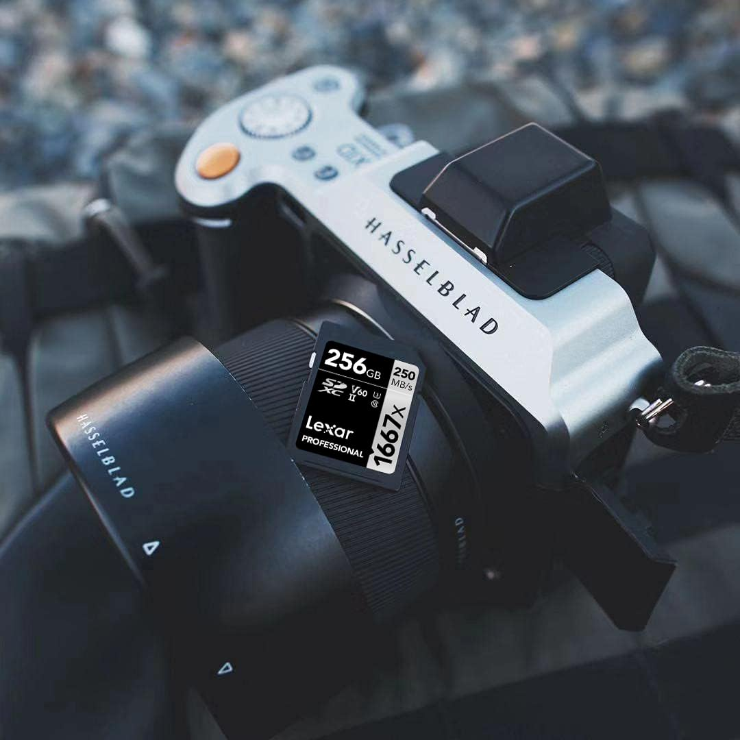 Un appareil photo Hasselblad argenté et noir avec une carte SD Lexar de 256 Go sur une surface sombre.