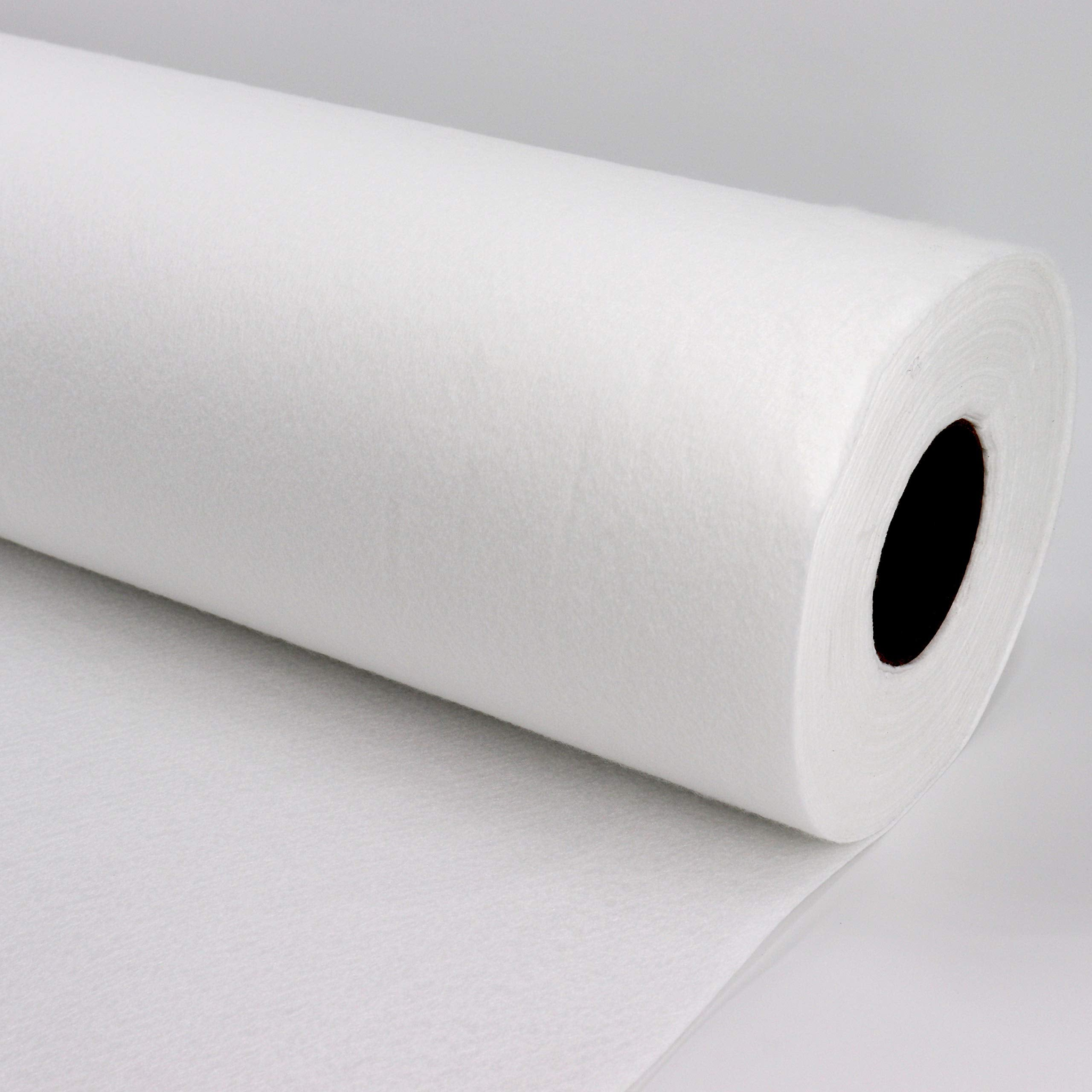Un grand rouleau de matériau molletonné blanc sur une surface lisse et gris clair.