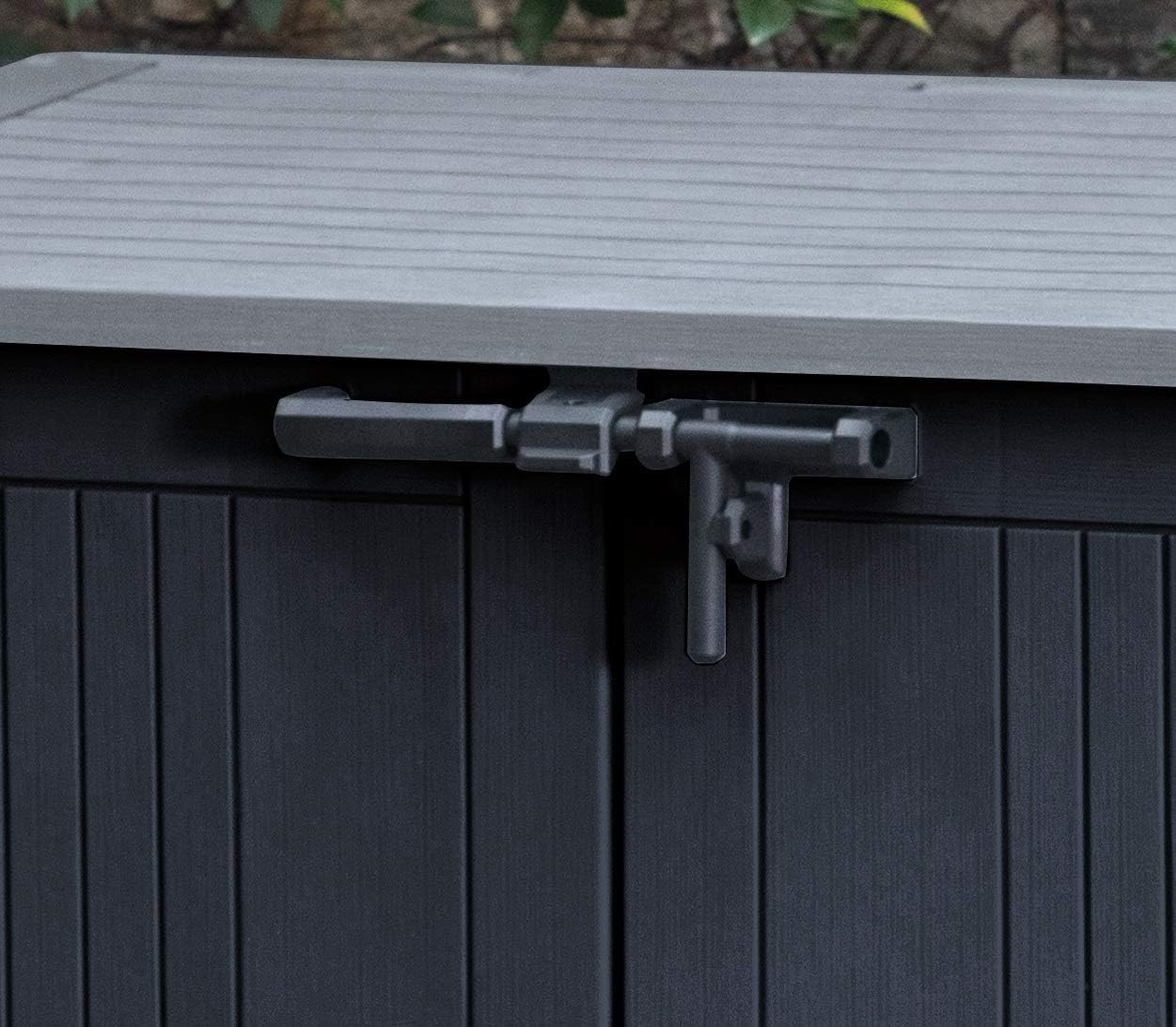 Une armoire de rangement grise en résine d'extérieur a un loquet coulissant noir sur ses portes.