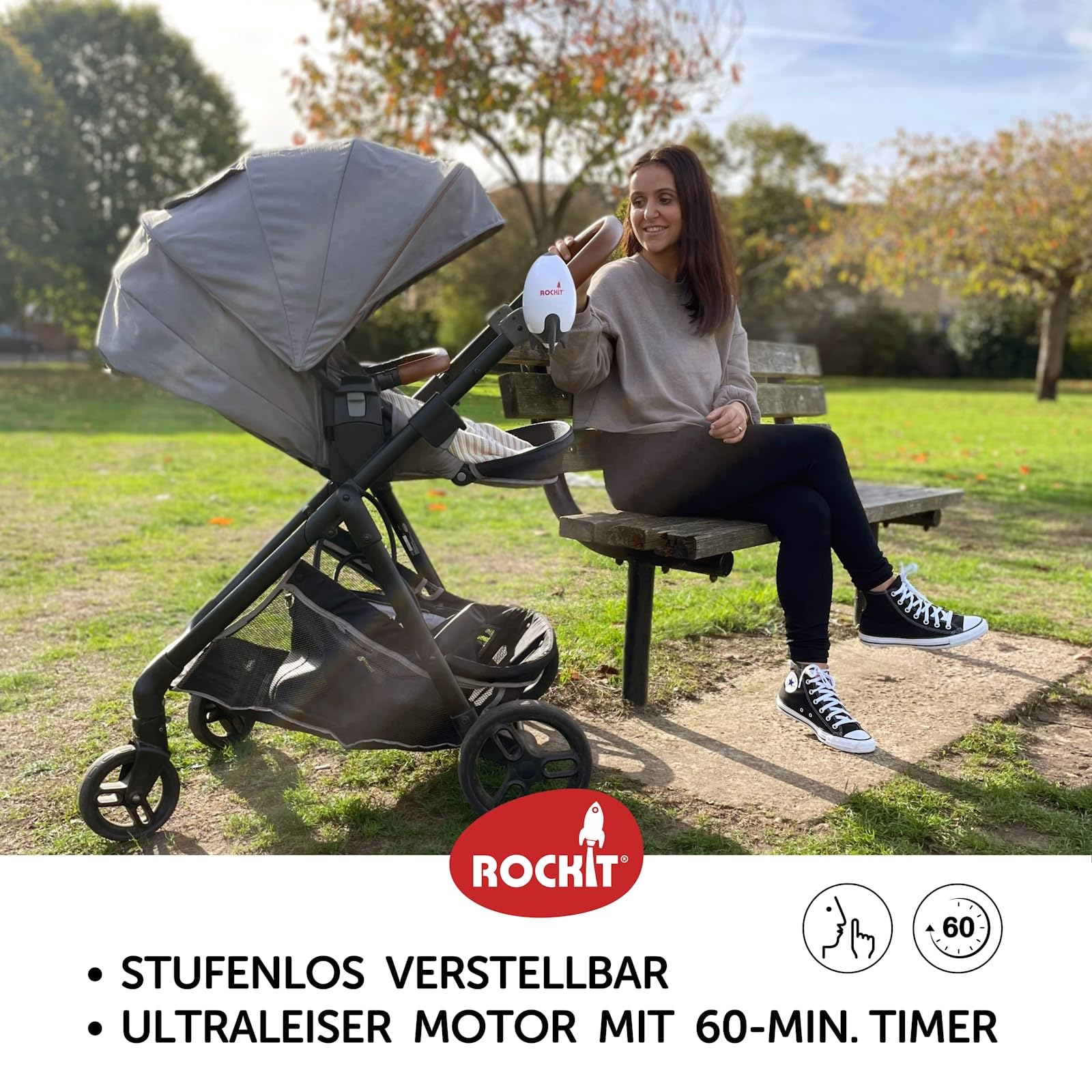 Une femme est assise sur un banc de parc à côté d'une poussette grise dans un parc ensoleillé.