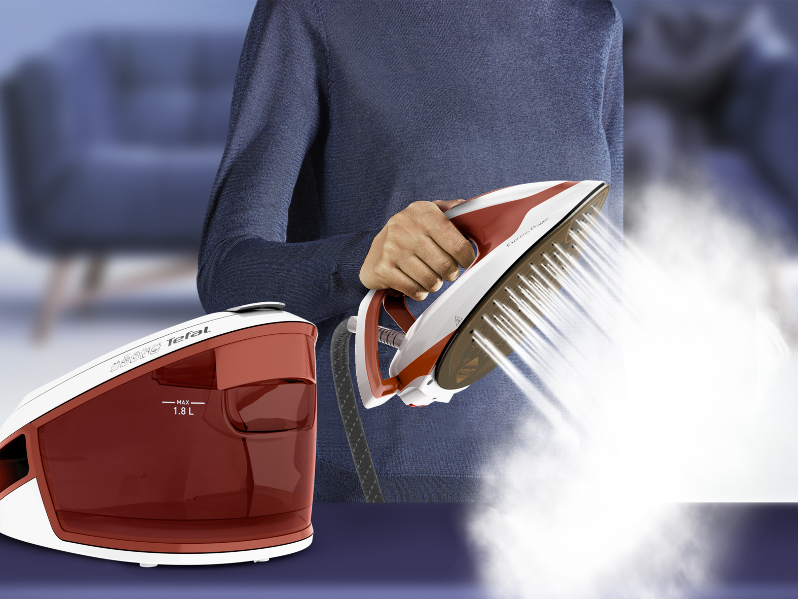 Eine Person hält ein rot-weisses Tefal Dampfbügeleisen, das starken Dampf ausstösst, neben der Basisstation.