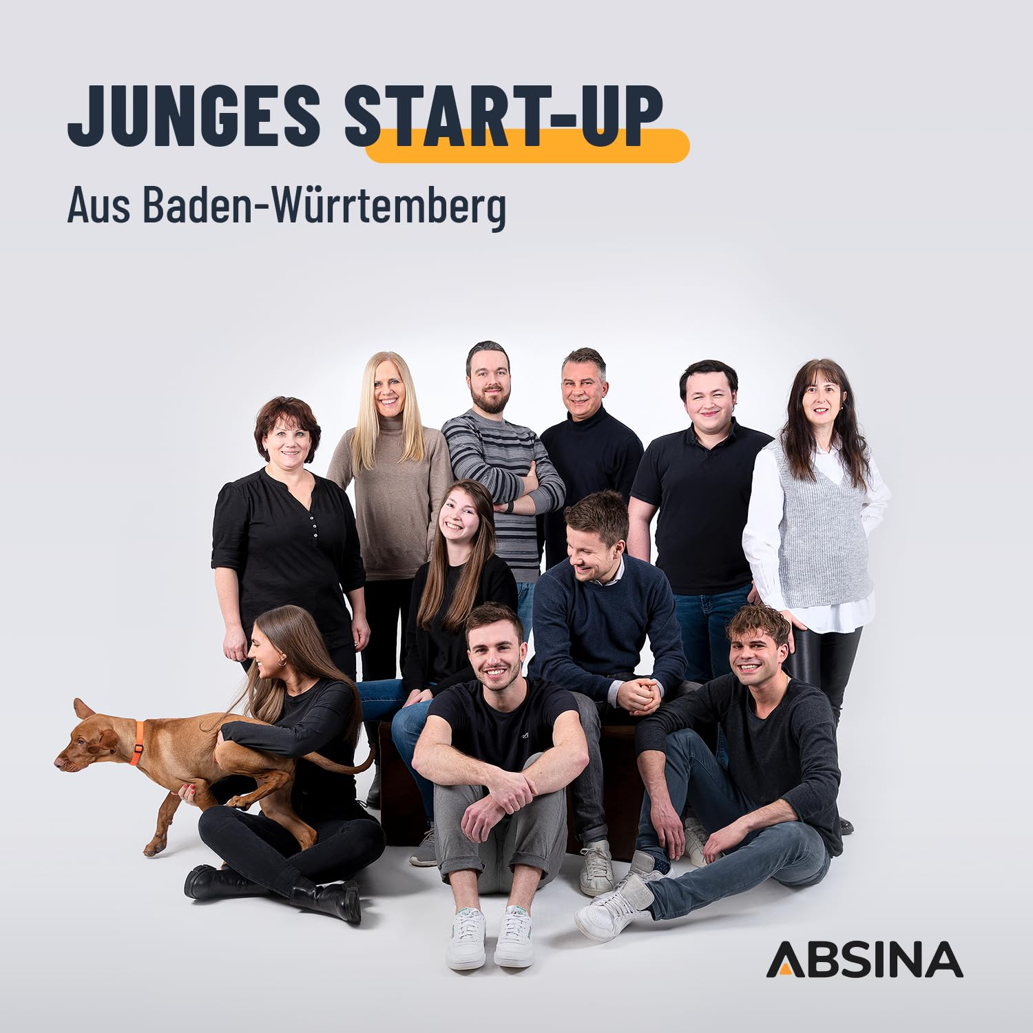 Un team di undici persone e un cane posa su sfondo grigio con la scritta Junges Start-up.