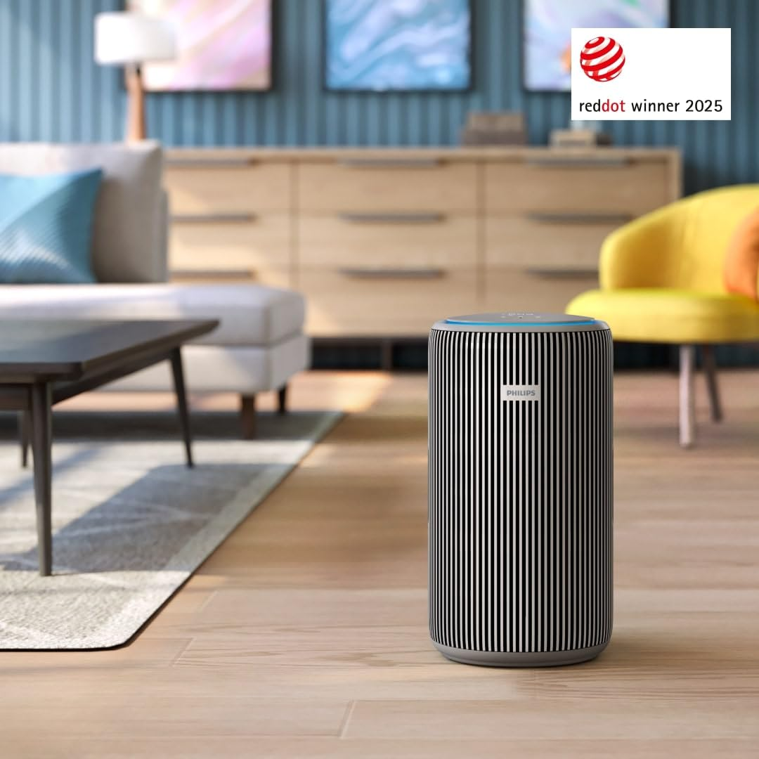 Ein schwarz-weiß gestreifter Philips-Luftreiniger steht auf einem Holzfußboden in einem modernen Wohnzimmer.