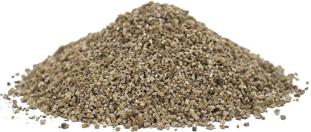 Un tas en gros plan de flocons de vermiculite gris-brun sur fond blanc.