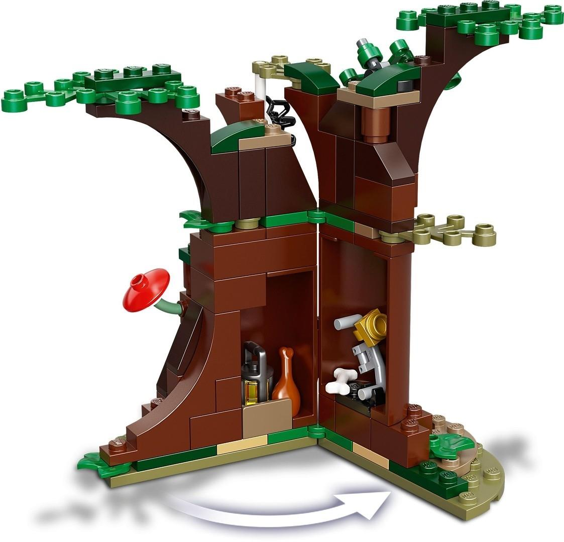 Ein hölzernes Lego-Baumhaus mit offenen Türen, die das Innere mit Fässern und Werkzeugen auf einer grünen Basis zeigen.
