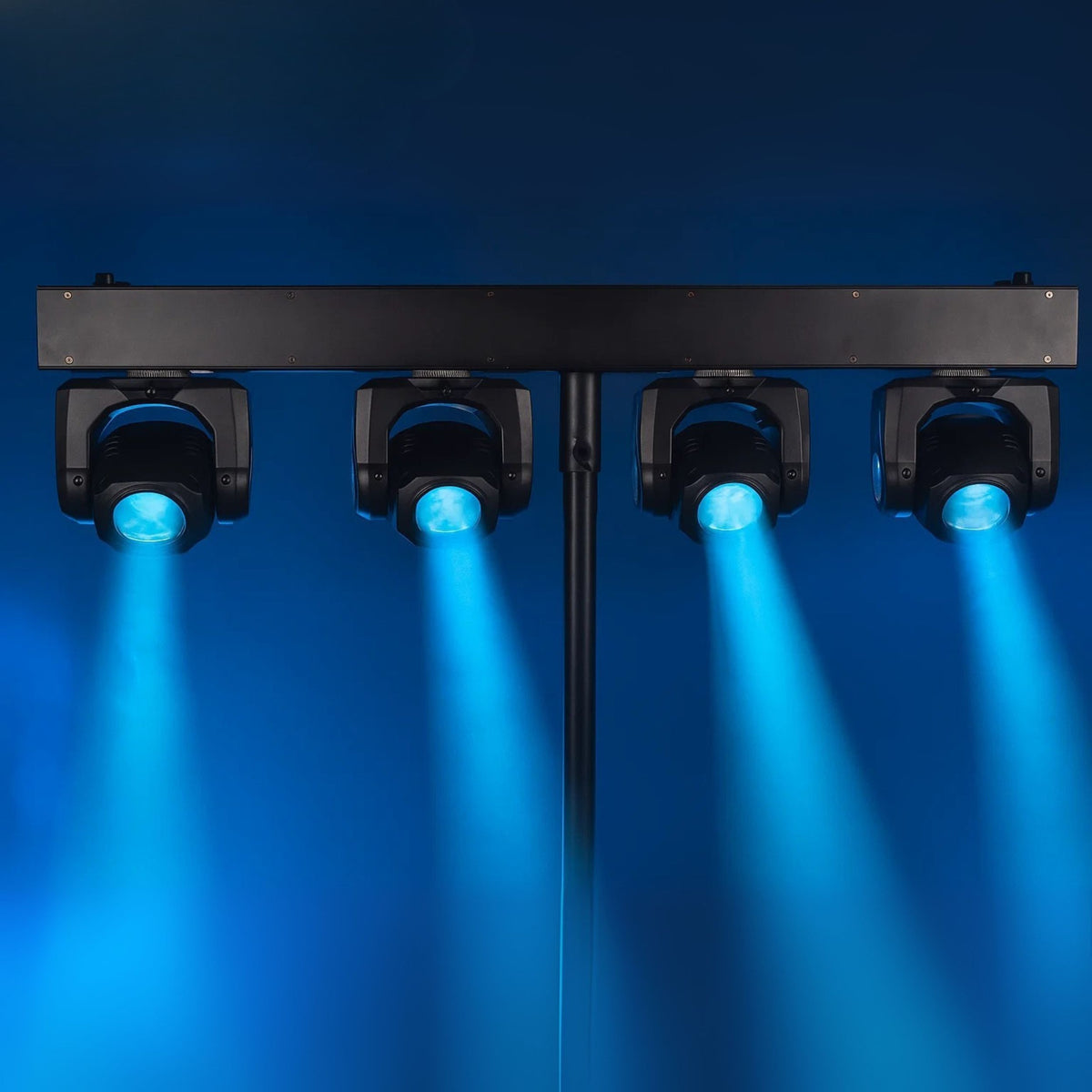 Vier schwarze Scheinwerfer auf einer Stange projizieren hellblaues Licht gegen einen blauen Hintergrund.