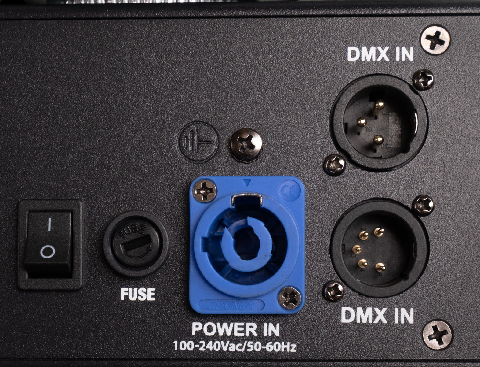 Rückseite eines elektronischen Geräts mit Netzschalter, Sicherung, blauer Power-In-Buchse und zwei DMX-In-Anschlüssen.