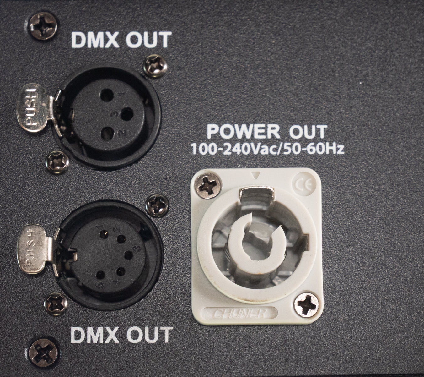 Rückseite eines Geräts mit zwei XLR-DMX-Ausgängen und einem Power-Out-Anschluss auf schwarzem Metall.
