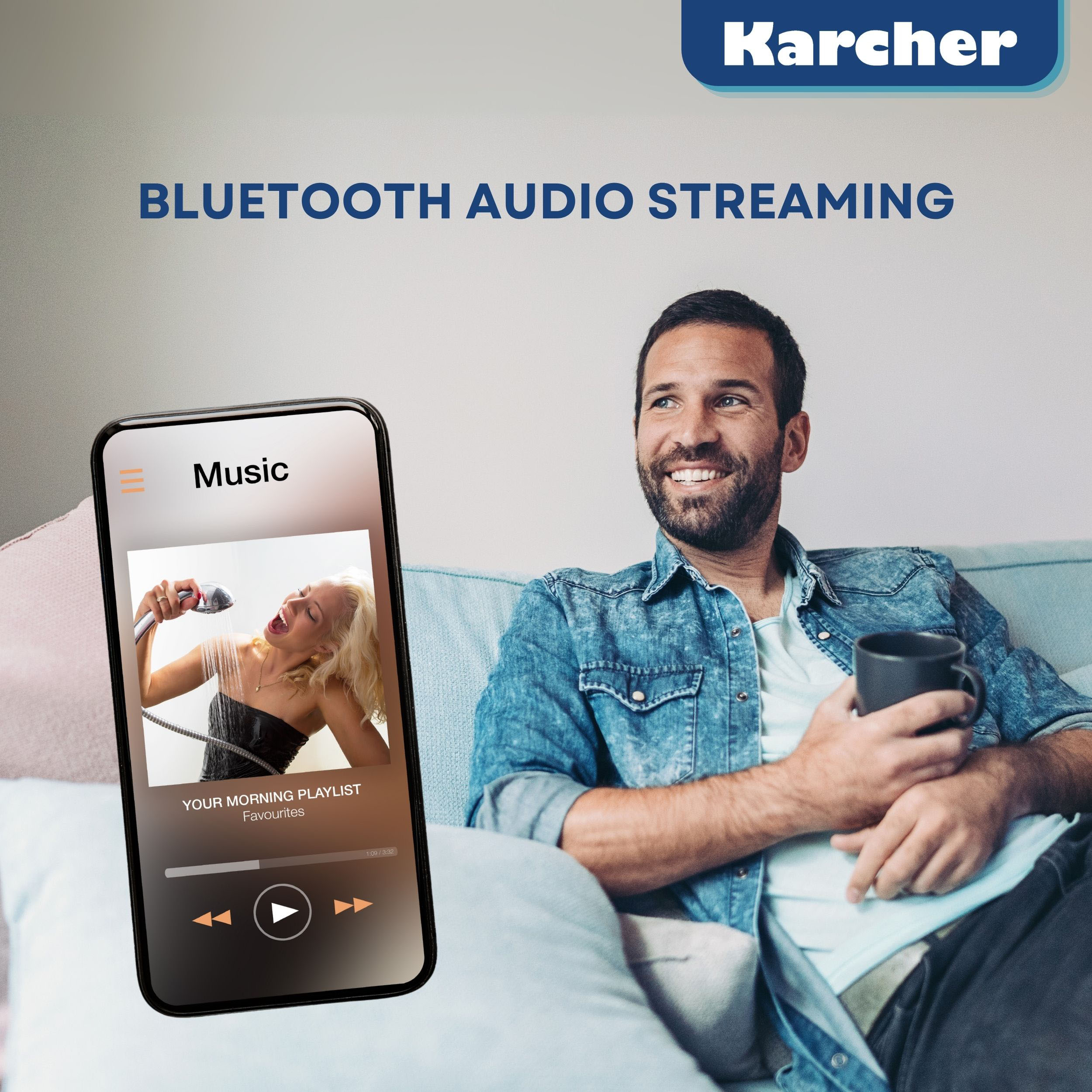 Ein Mann sitzt auf einer Couch, hält eine Tasse, während ein Smartphone davor eine Musik-App anzeigt.