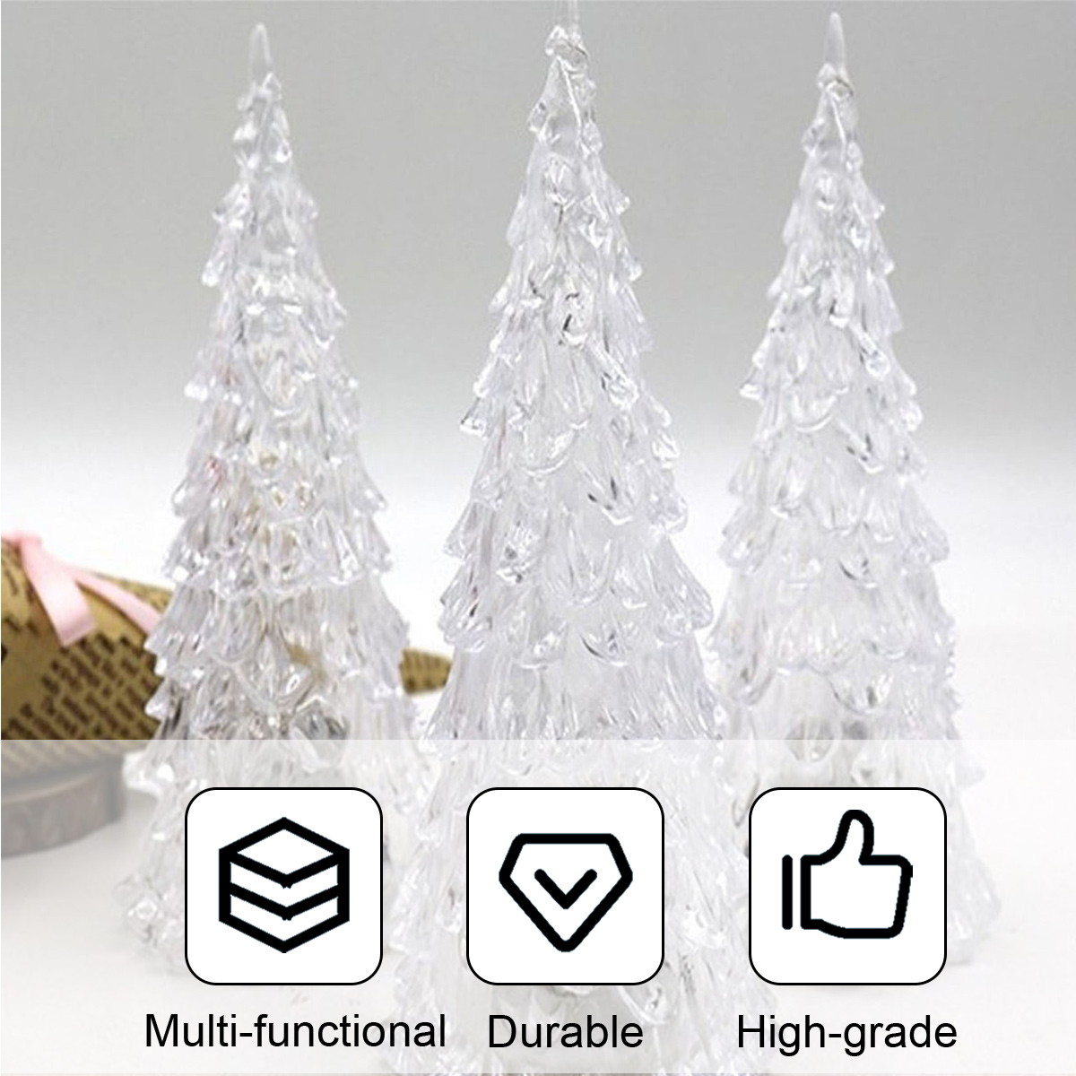 Drei klare, glänzende Weihnachtsbaumfiguren auf hellem Hintergrund mit drei Symbolen und Text darunter.